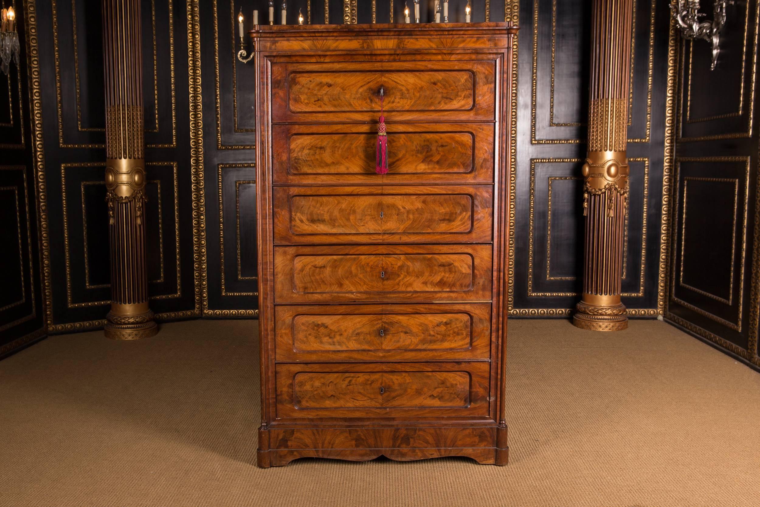 Mahogany on softwood. Rectangular body with curved profile cornice ending in pad feet. In the front six drawers with pyramidal grains.