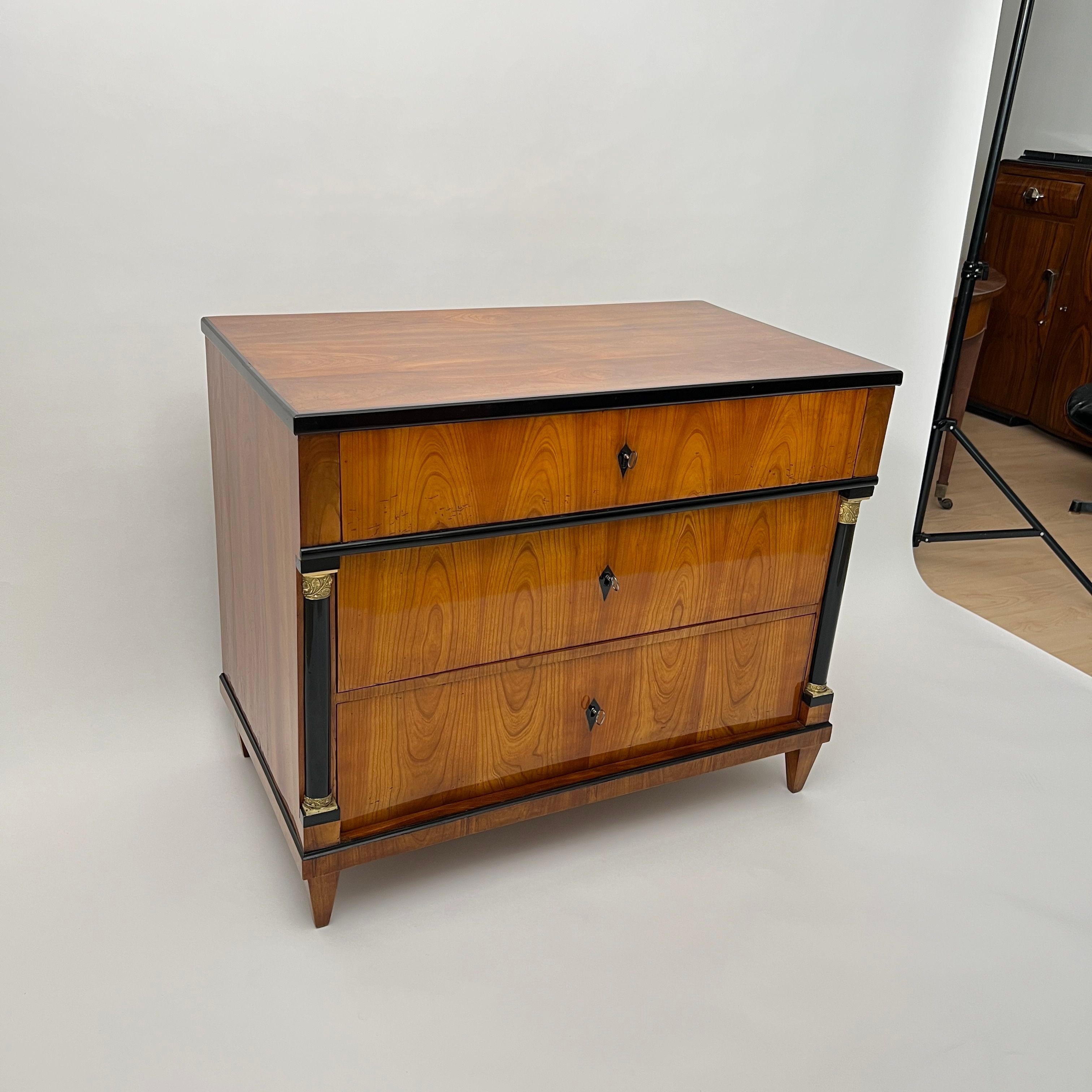 Bellissima cassettiera Biedermeier del 1820 circa, proveniente dalla Germania meridionale.
Ciliegio impiallacciato su legno dolce. Finiture, chiavi e semicolonne ebanizzate
Meravigliosi capitelli in ottone con motivi di foglie di fiori. All'interno