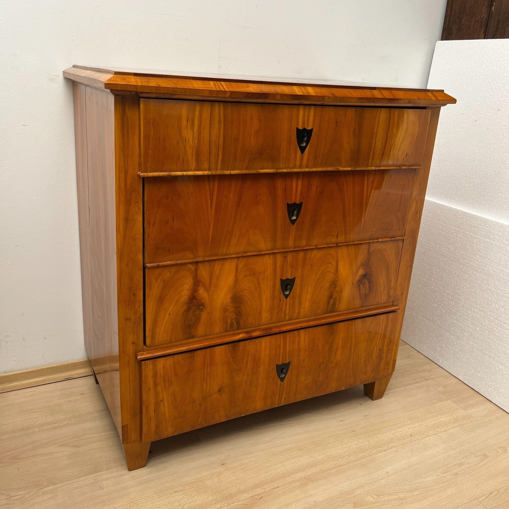 Beautiful, small 4-drawer Biedermeier Commode or Chest of drawers in cherry wood from South Germany, circa 1830.
Cherry wood veneer on softwood and solid wood. Standing on low square legs. Ebony key escutcheons inlaid. Original box locks and 1