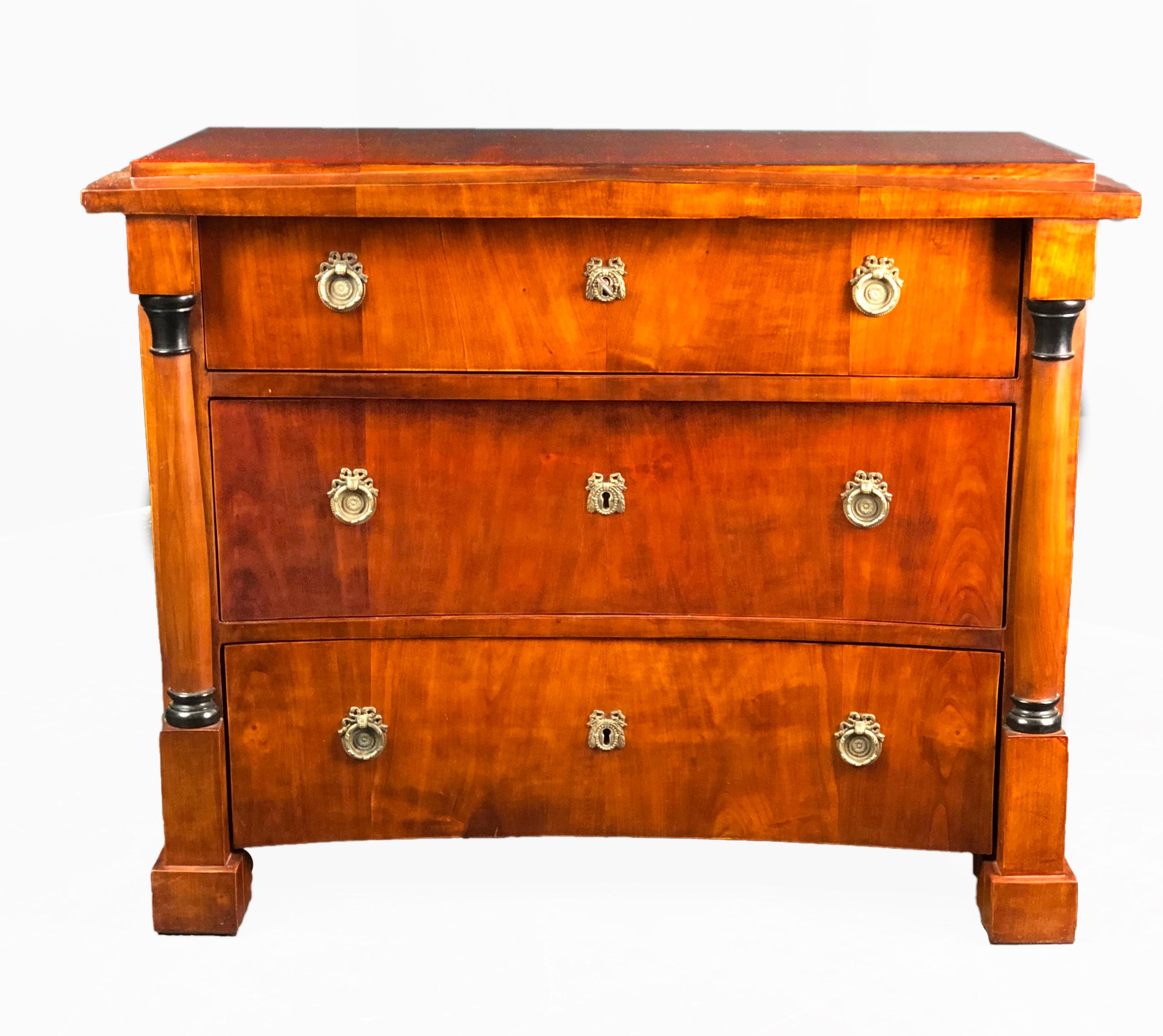 Outstanding and rare Biedermeier cherrywood commode with 3 drawers dating to early 19th century Germany. The architectural shape features a Schinkel style pediment and 3 drawers, the lower 2 of concave shape, a quite unusual feature; they are