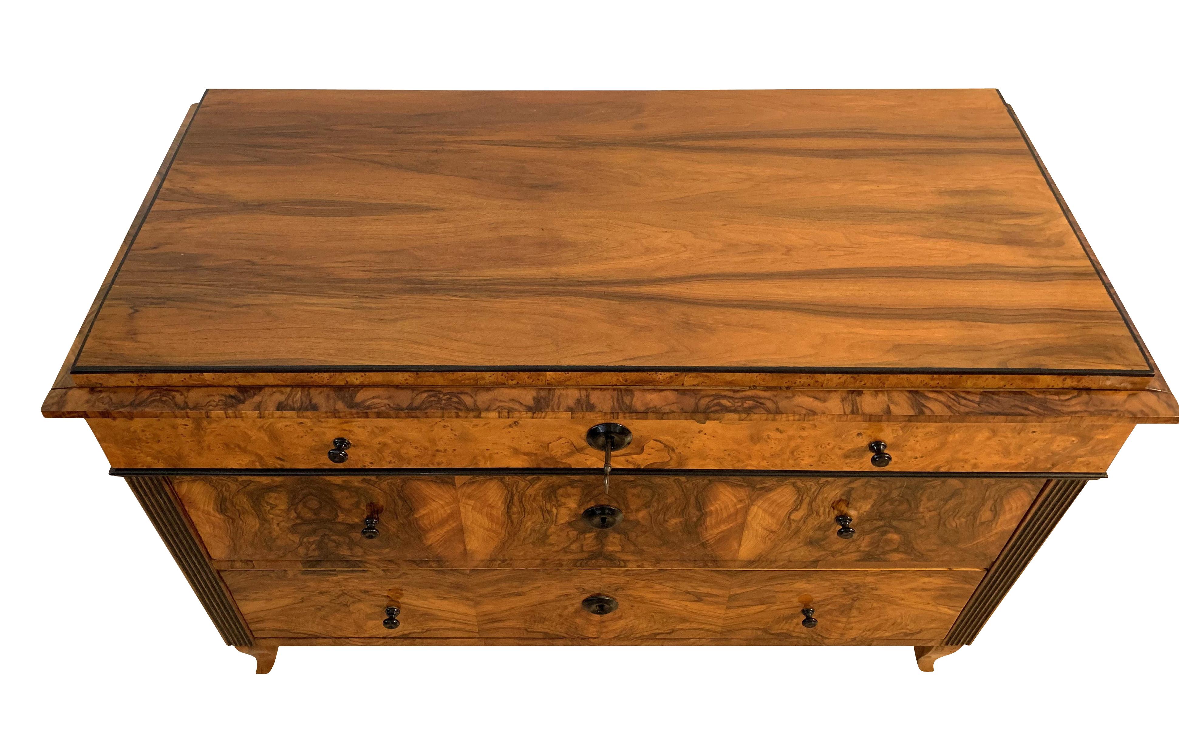 Wonderful neoclassical Biedermeier Commode / Chest of 3 Drawers from Austria around 1820.

Walnut and Ash Burl Veneered, French polish, partly ebonized.

Cannelured and inside ebonized Pilaster Strips. Top drawer connected with front of the cornice.
