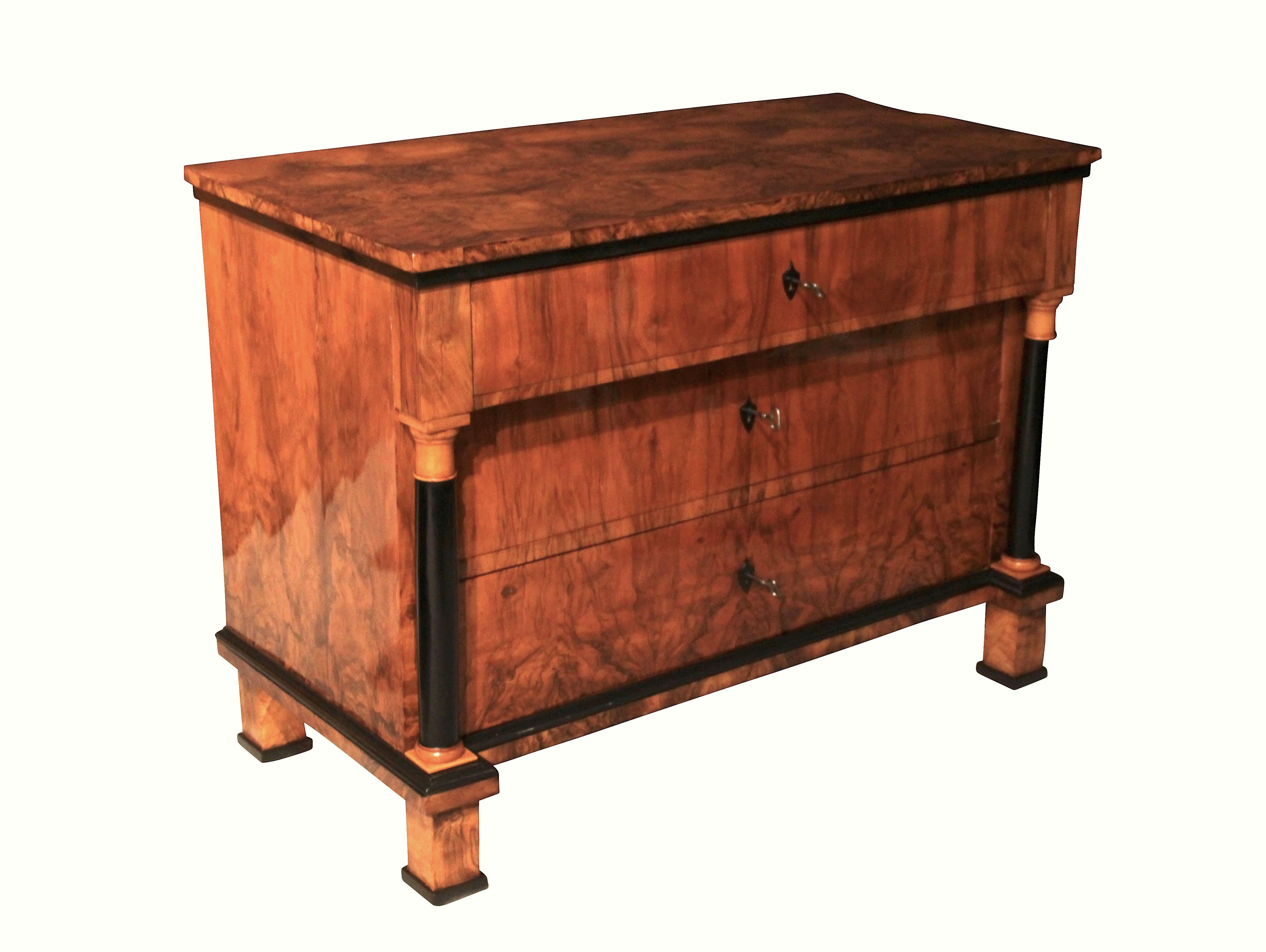 Elegant, early Biedermeier commode in walnut veneered and French polished.

3 drawers, ebonized full-columns.
Original ebonized put-on key plates. Original locks.

Dimensions: 
Inch: H 34.6, B 47.2/46, D 23.2/22.4 in
Cm: H 88, B 120/117, T