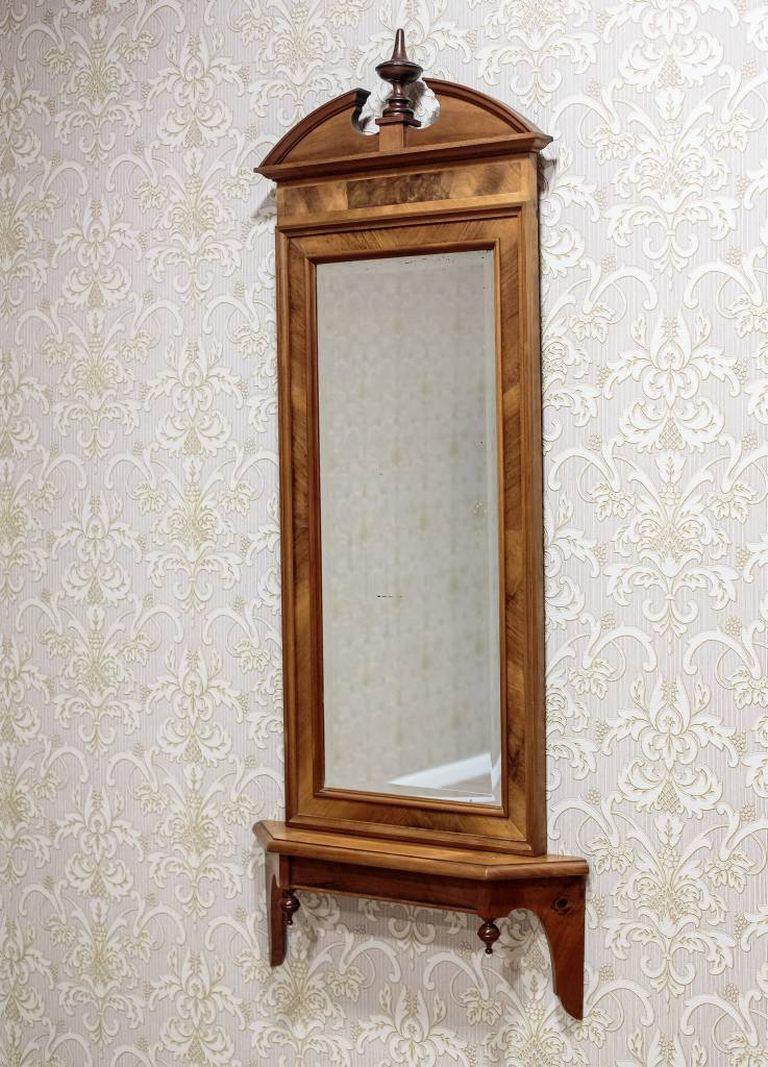 An interesting Biedermeier mirror, circa 1880, in a wooden frame of mahogany veneer.
The simple frame of the mirror ends with an irregular crest with a finial. The mirror is old and beveled.
The whole is original, the frame and the console are in