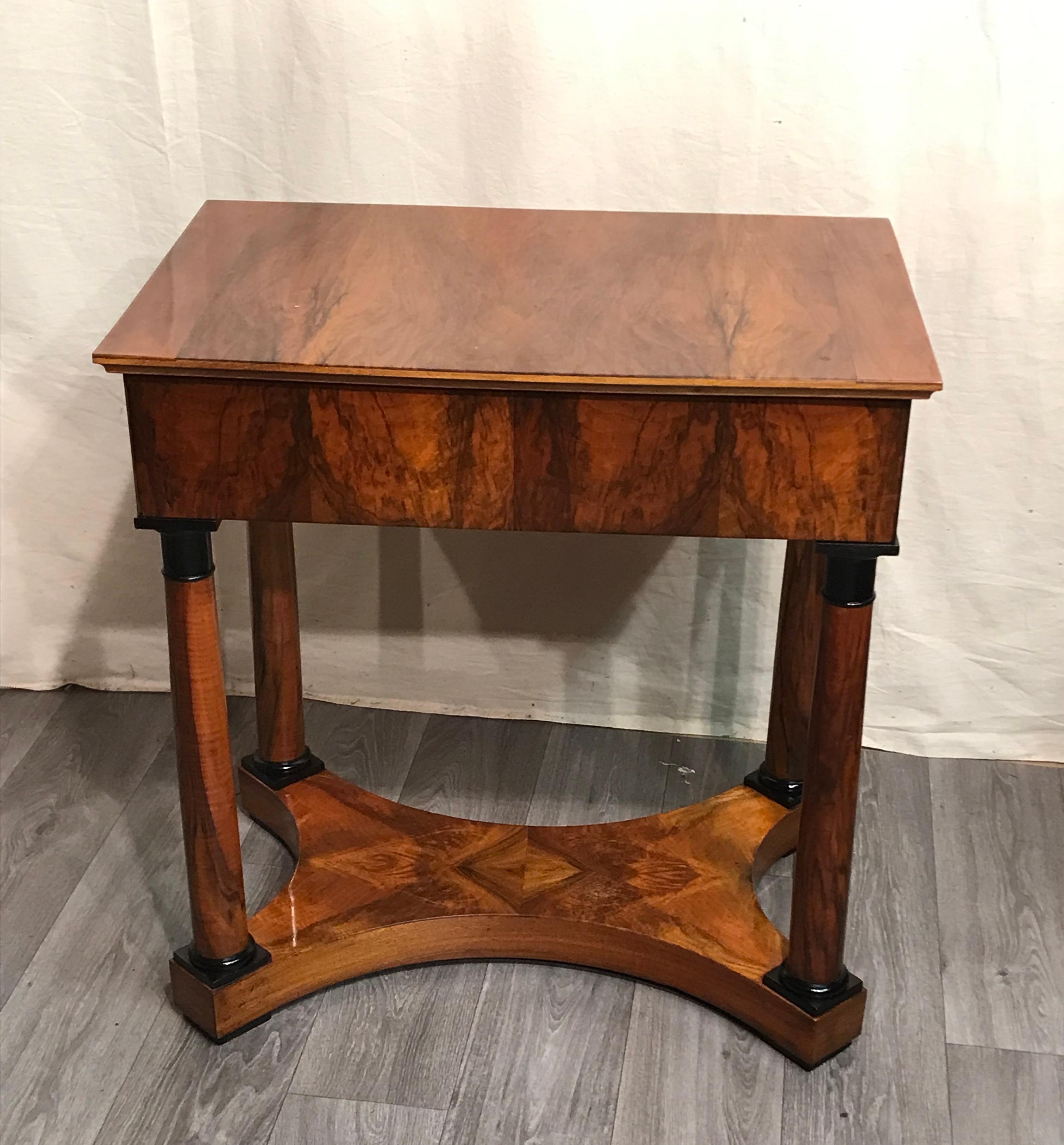 Unique Biedermeier console table which dates back to 1820 and comes from southern Germany. This elegant console table stands out for its classic Biedermeier design. The four columnar feet stand on a beautifully veneered plinth. The columns have