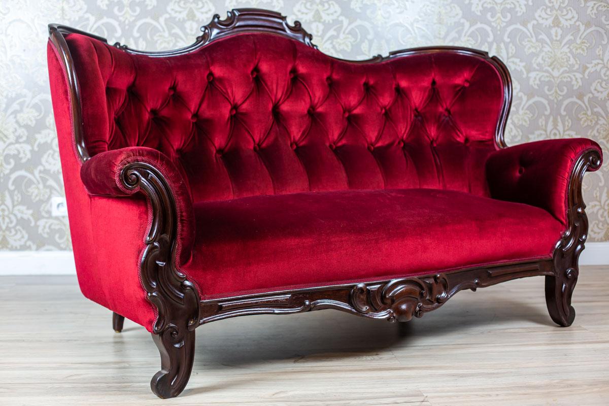 We present you an exquisite, big walnut sofa with a softly upholstered seat, sides, and a strikingly padded backrest.
This piece of furniture is from the Interwar Period, stylized as Biedermeier furniture.
The sofa legs are in the shape of volutes