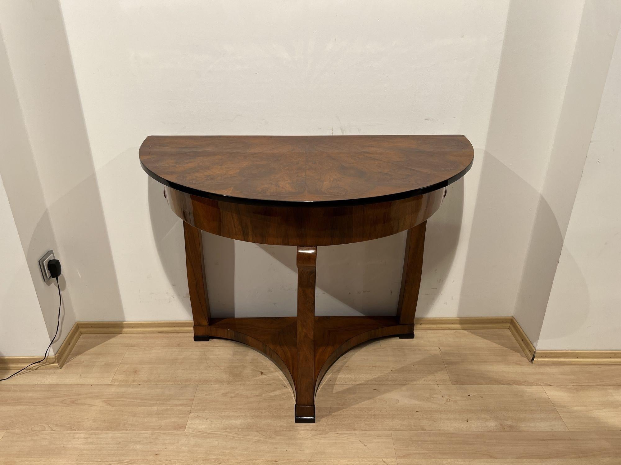 Biedermeier Demi-Lune console table, walnut veneer, maple, Austria circa 1830

Three-legged demi-lune console table in walnut. Half round top in walnut star veneered and maple inlay band. Three solid walnut legs connected by veneered triangular