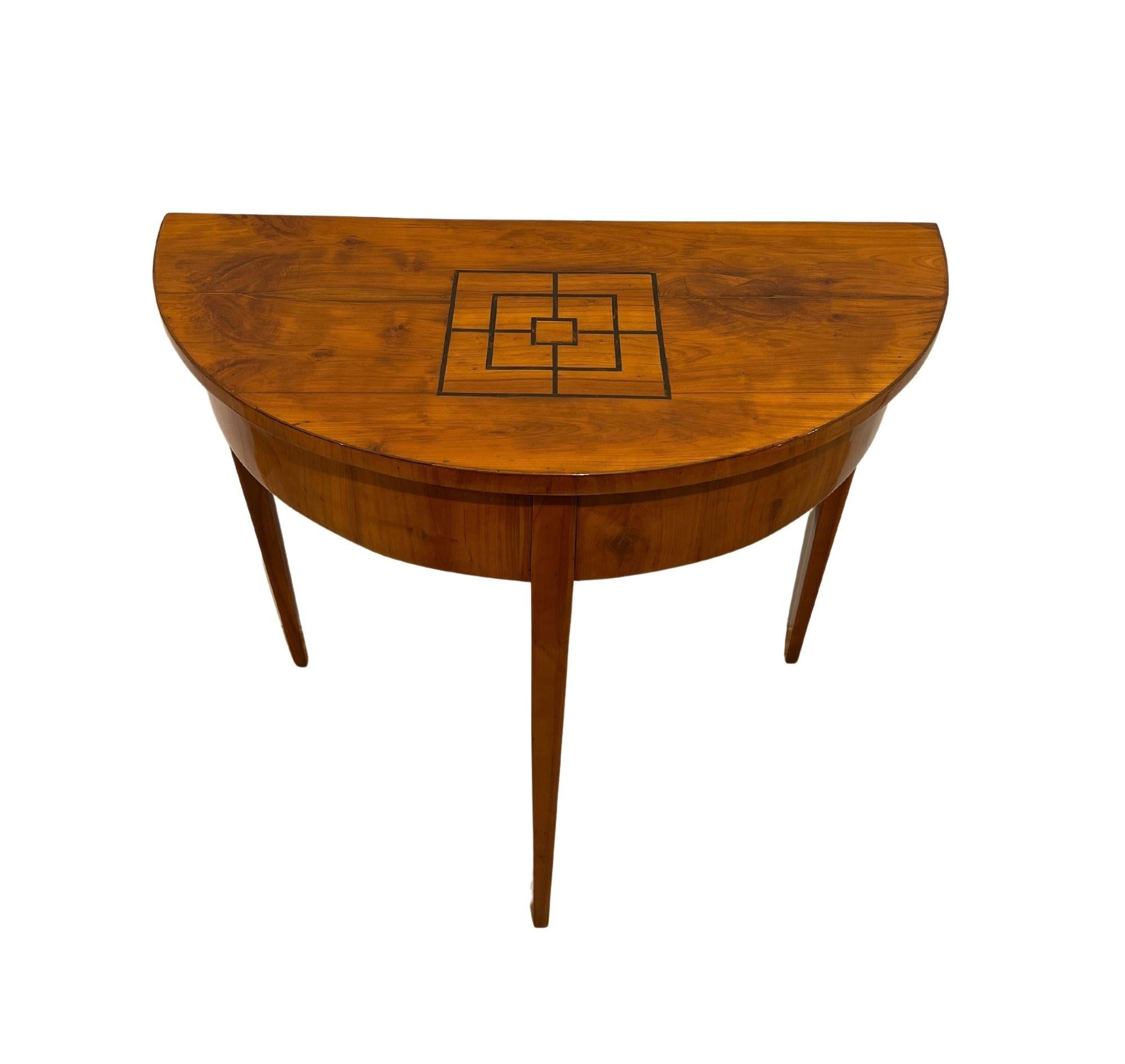 Biedermeier Demi Lune table, Cherry Wood, South Germany circa 1820.
 
Cherry wood veneered and solid, hand polished with shellac. Ebony inlays on the plate in form of a mill game board. Frame is veneered, the top is cross veneered and book-matched.