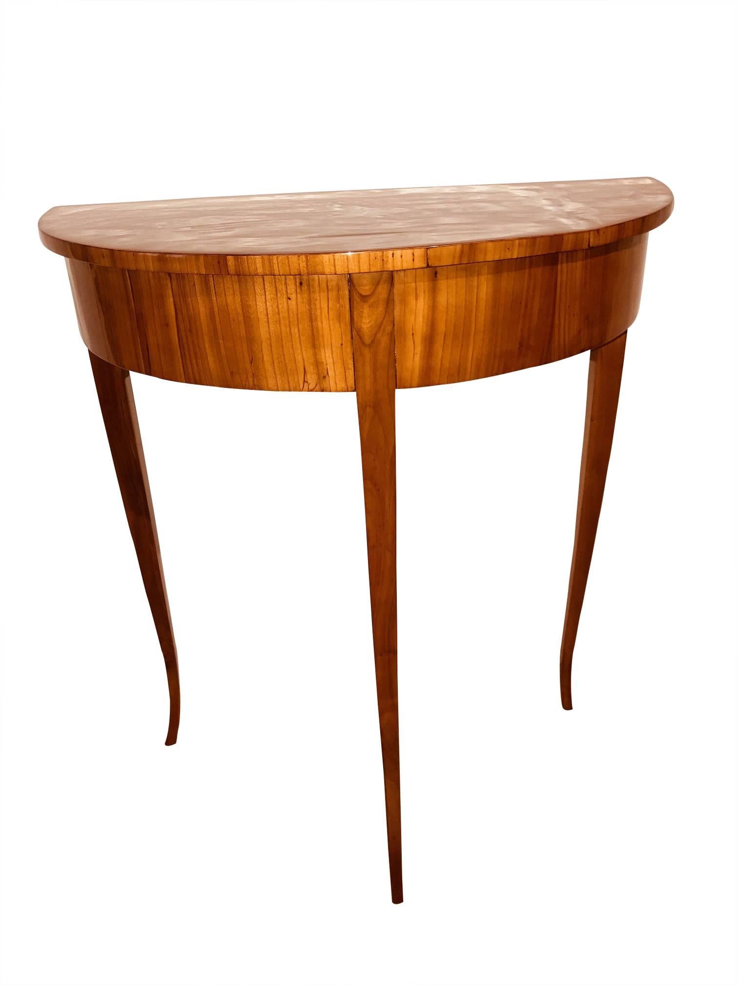 Very elegant, rare, small demilune (half-moon) side table made from cherry solid wood and veneer. Early Biedermeier, South Germany circa 1820. Beautifully light shaped conical legs. Hand-polished with shellac.