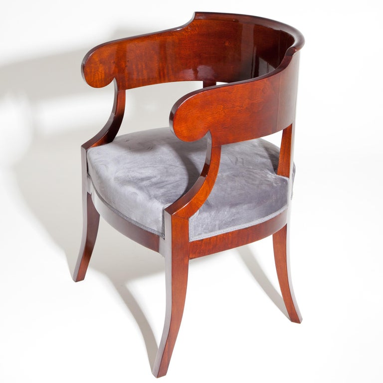 Biedermeier desk chair out of mahogany with a broad backrest. The seat was upholstered with a grey velvet fabric.