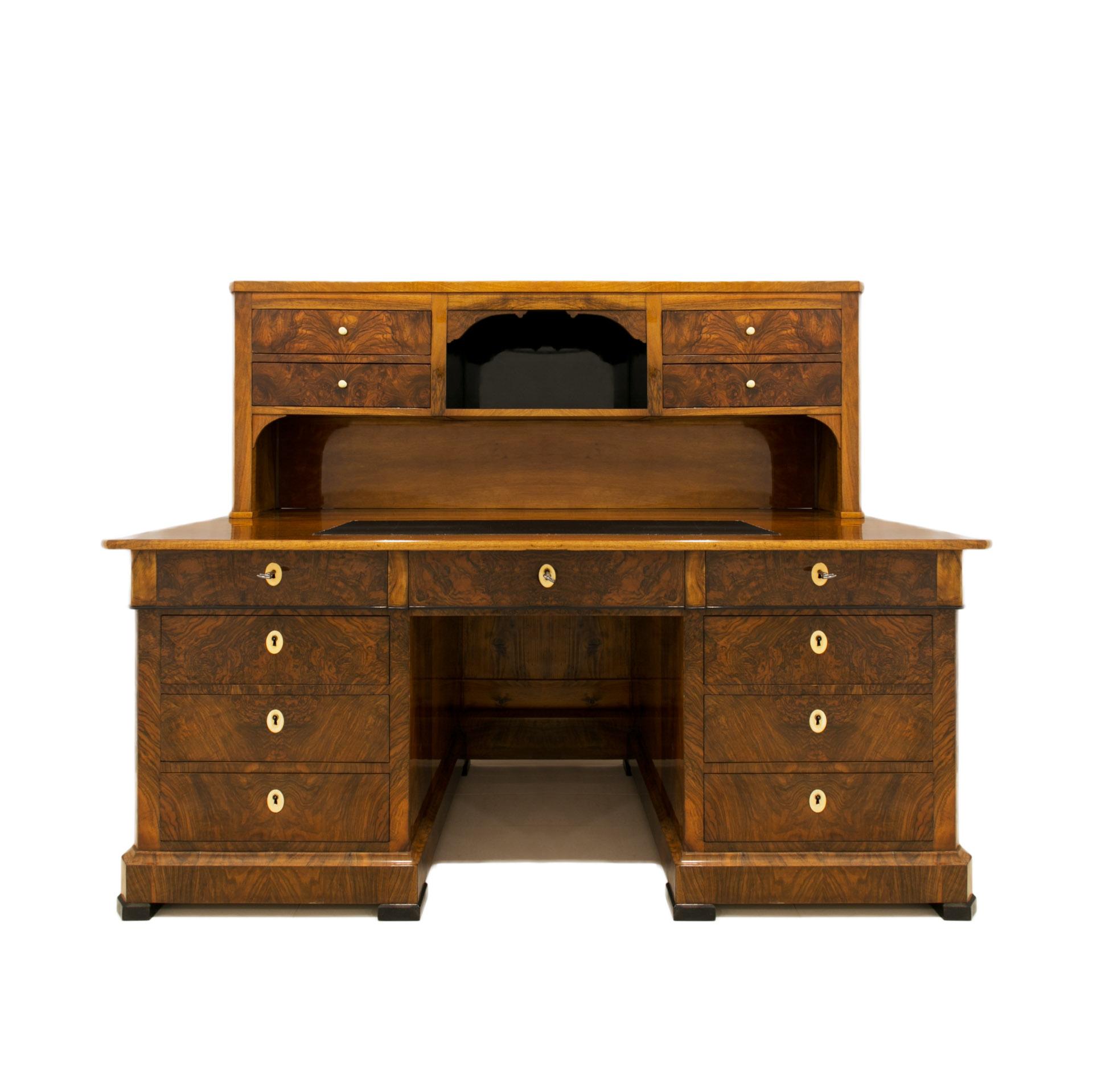 This is a beautiful desk from the Biedermeier period. It comes from Germany and was made in 19th Century. A very elegant and functional piece of furniture, veneered with walnut. The desk has two rows of lockable drawers, the top has a leather cover.