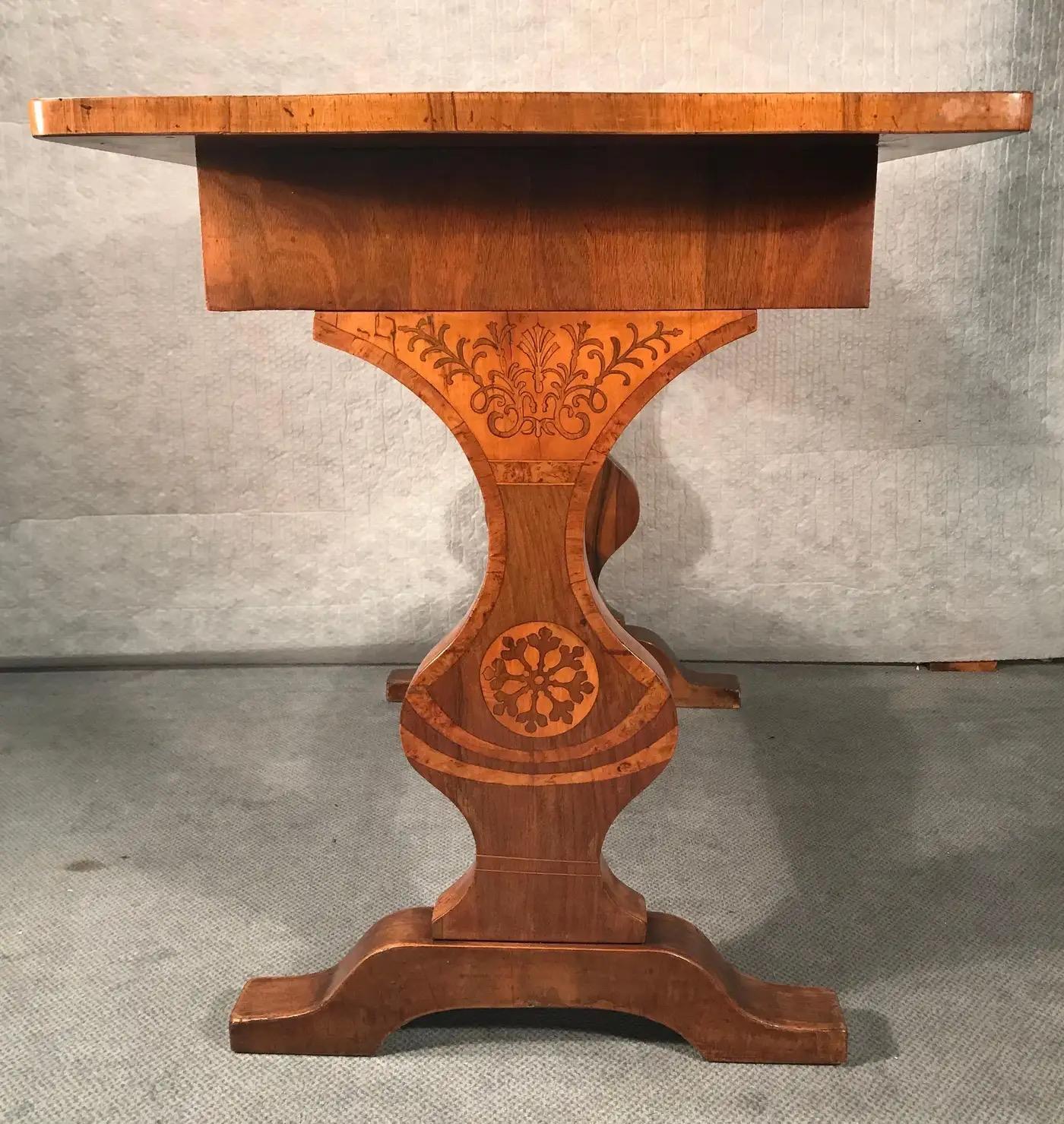 Biedermeier desk, Vienna 1820-1825, walnut with maple marquetry. The top and the end panels with beautiful flower and vine decor. The table is in good original condition. If required it can be refinished and French polished in our workshop, please