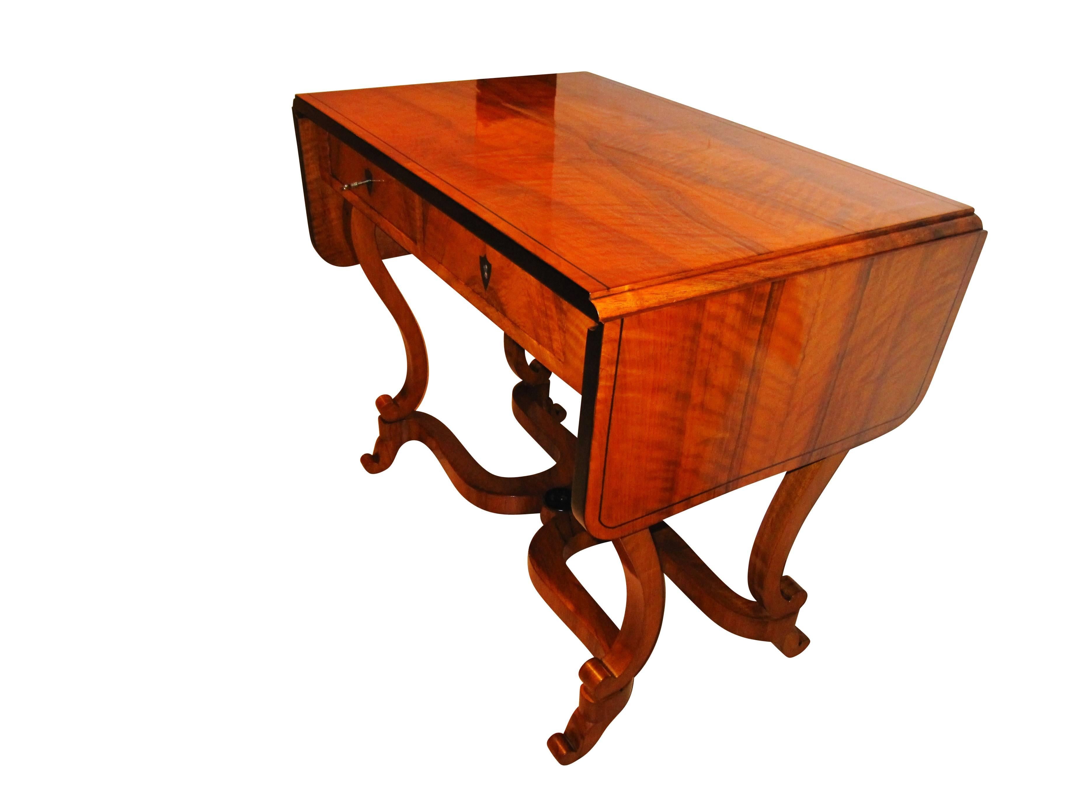 Very special and rare Biedermeier desk from South Germany, circa 1830. The desk is made from a beautiful book-matched walnut veneer and solid wood and has been hand-polished with shellac. The legs are made in form of a Lyra. It has two drawers at