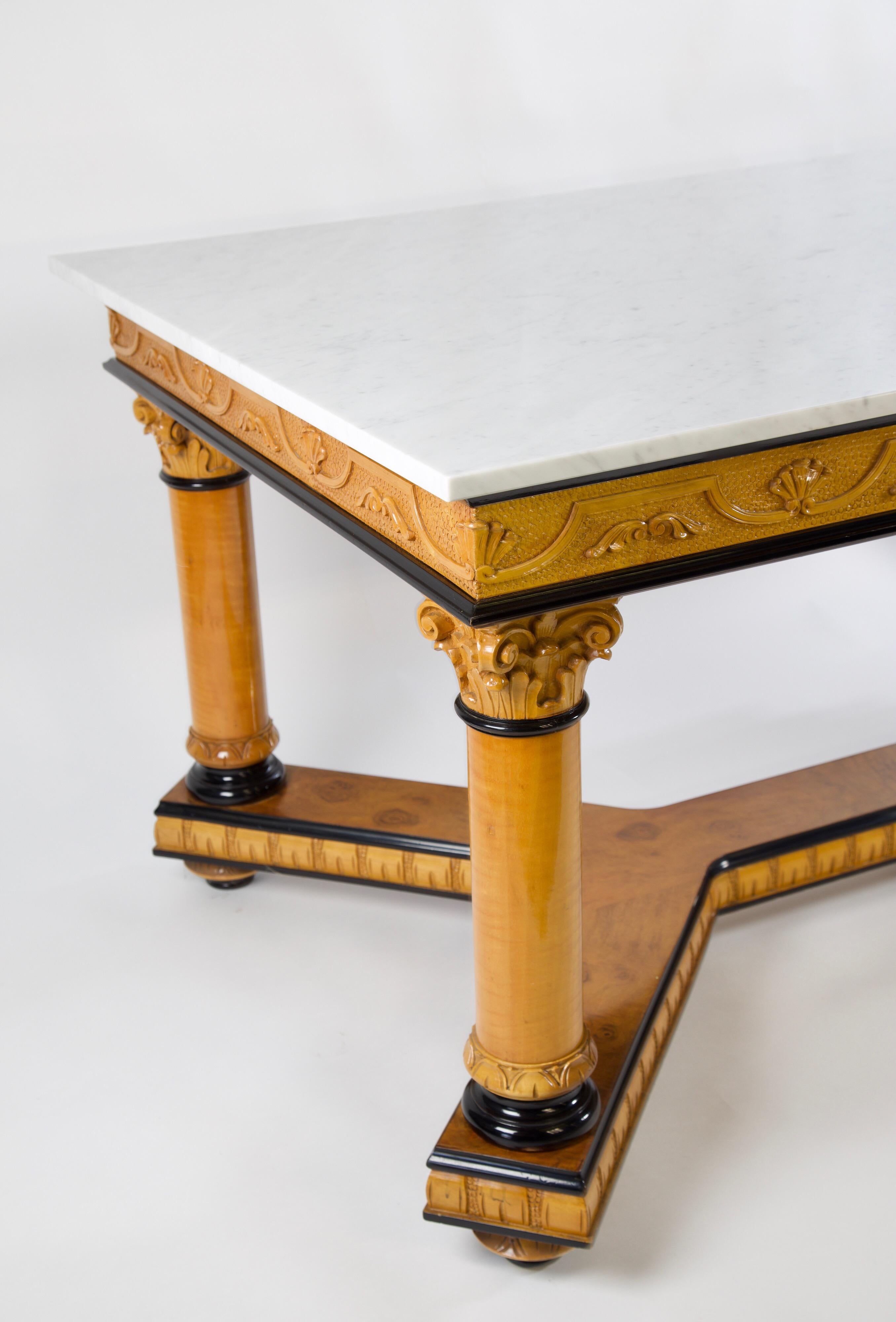 Biedermeier dining table with bird's-eye maple veneer and Carrara marble. Could be used in a library, as an entry table, dining table or even a desk. This piece of art has an acanthus leaf design atop capitals of the column legs with black ebonized