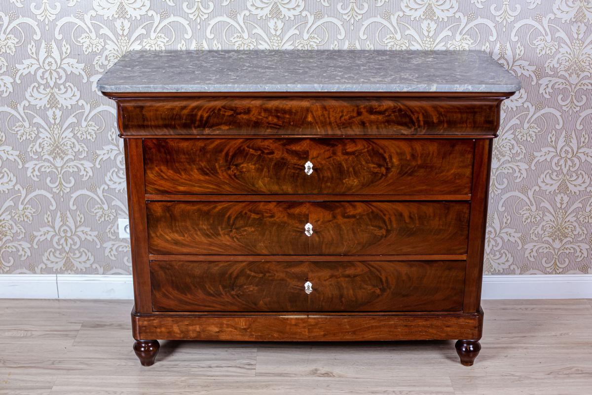 We present you a big dresser in mahogany veneer. The whole is circa 1840.
The chest section has a slightly protruding bottom cornice and four drawers.
All topped with a stone board.
The drawer under the top is narrower than the rest.
Also, its