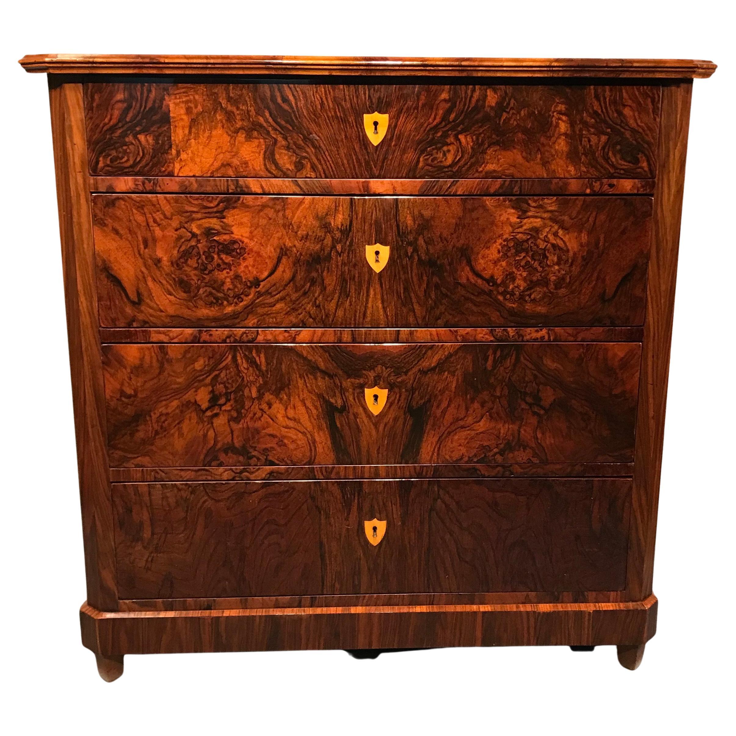 This unique Biedermeier Dresser of the 1820's was made in Southern Germany. The four drawers commode has a very pretty walnut veneer on a pinewood body. The escutcheons are made of bone inlays. The commode has been professionally refinished with a