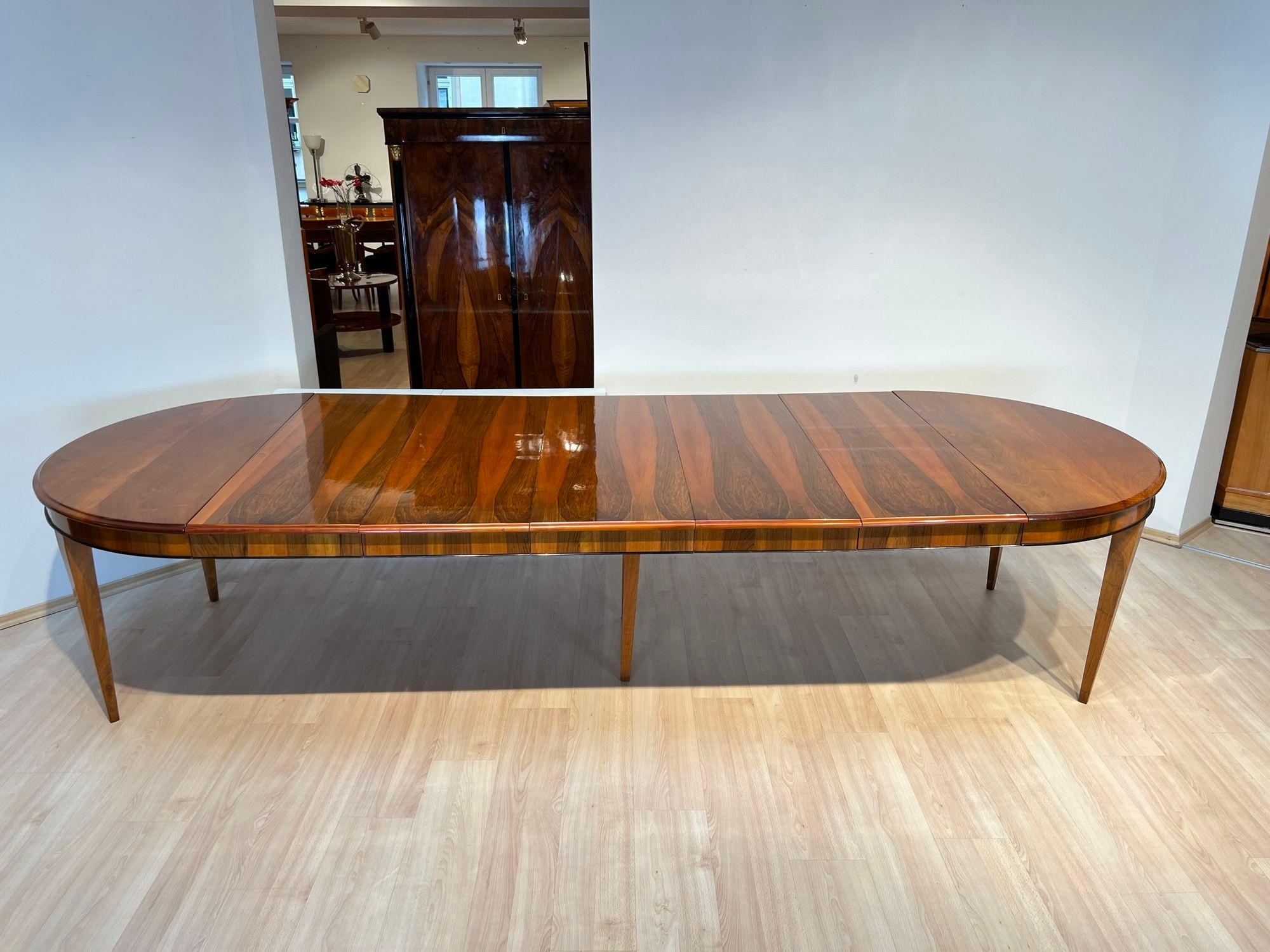 Large neoclassical Biedermeier expandable / extending dining room table in walnut and oak from Southwest Germany around 1830. 

Solid walnut wood side plates and conical square pointed legs. Carved notch all around the top edge and ebonized