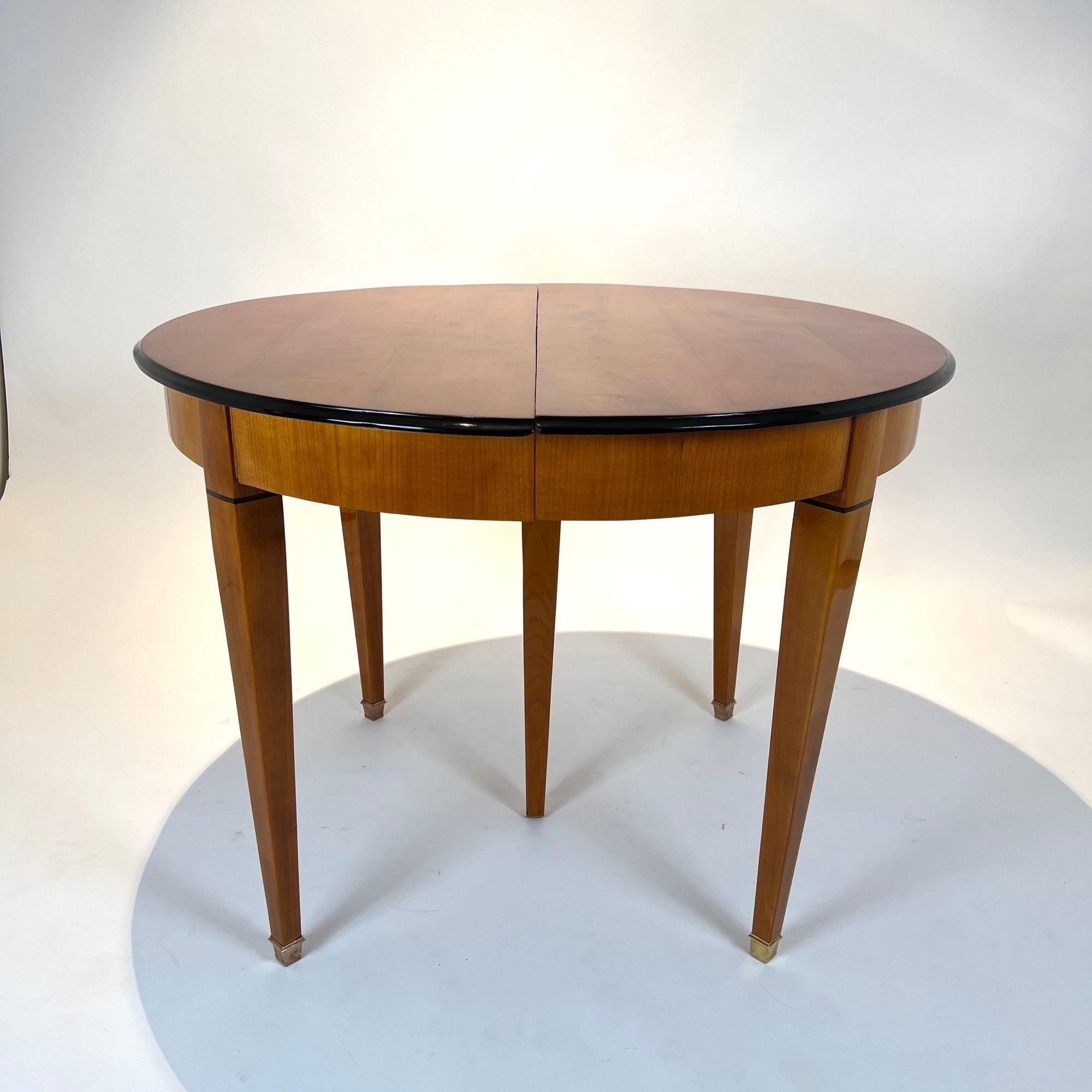 Round Biedermeier extendable table in cherry wood from Southwest Germany around 1830
Cherry veneered and solid. Ebonized notches around the edge.
Original extension mechanism in solid oak. Tapered square legs with inlaid ebony band.
Three 50 cm