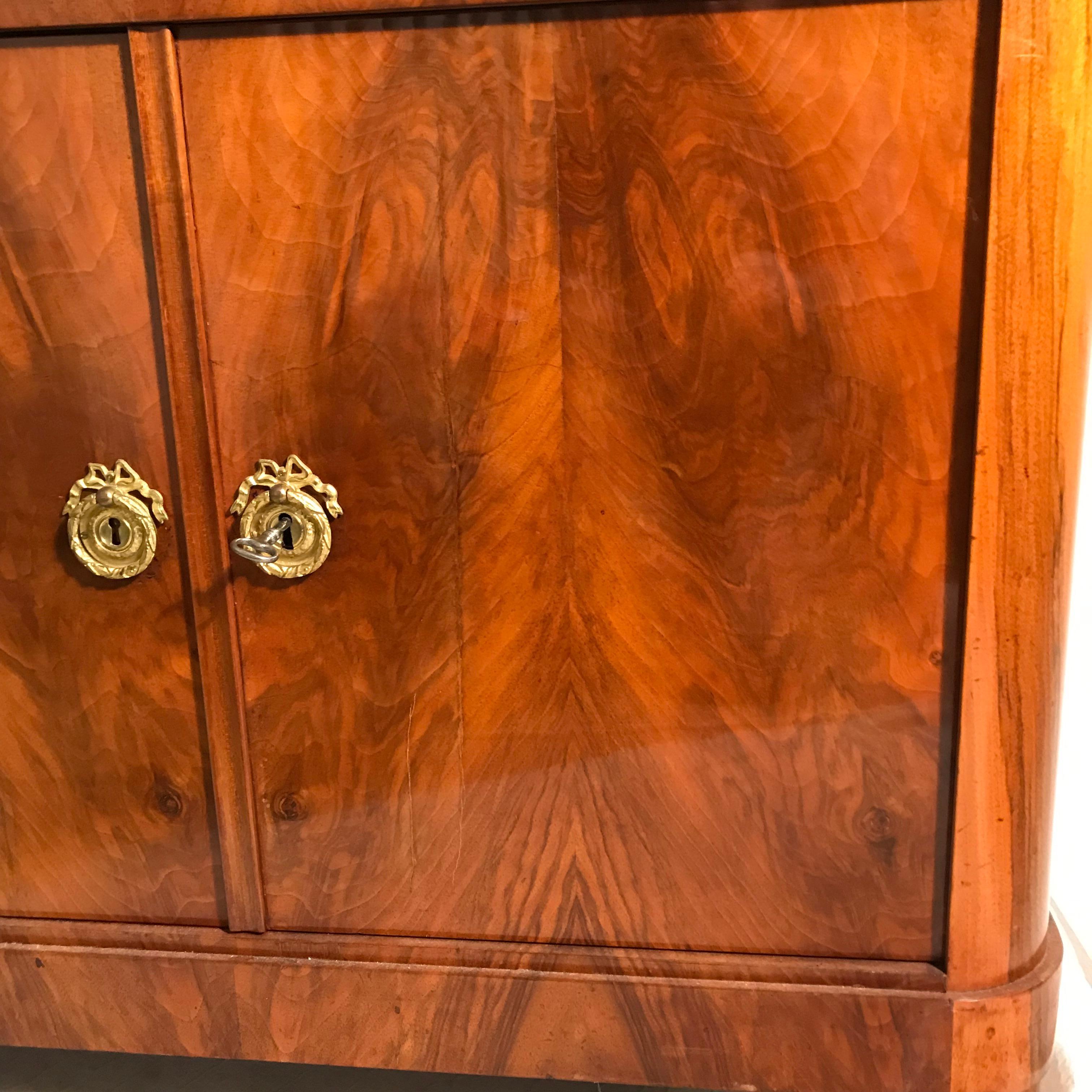 Classic Biedermeier fall top desk, South German, 1820, walnut veneer on the outside and mahogany veneer on the inside. It has a beautiful veneer grain. The desk has been refinished in the past and is in good condition. There is one veneer crack on