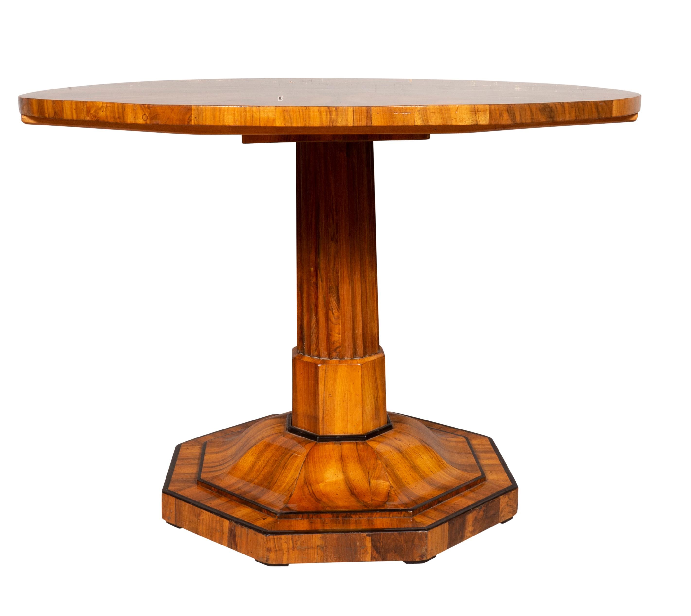 Circular hinged top with sunburst inlay creating a star. Fluted columnar support joining an octagonal plinth base.