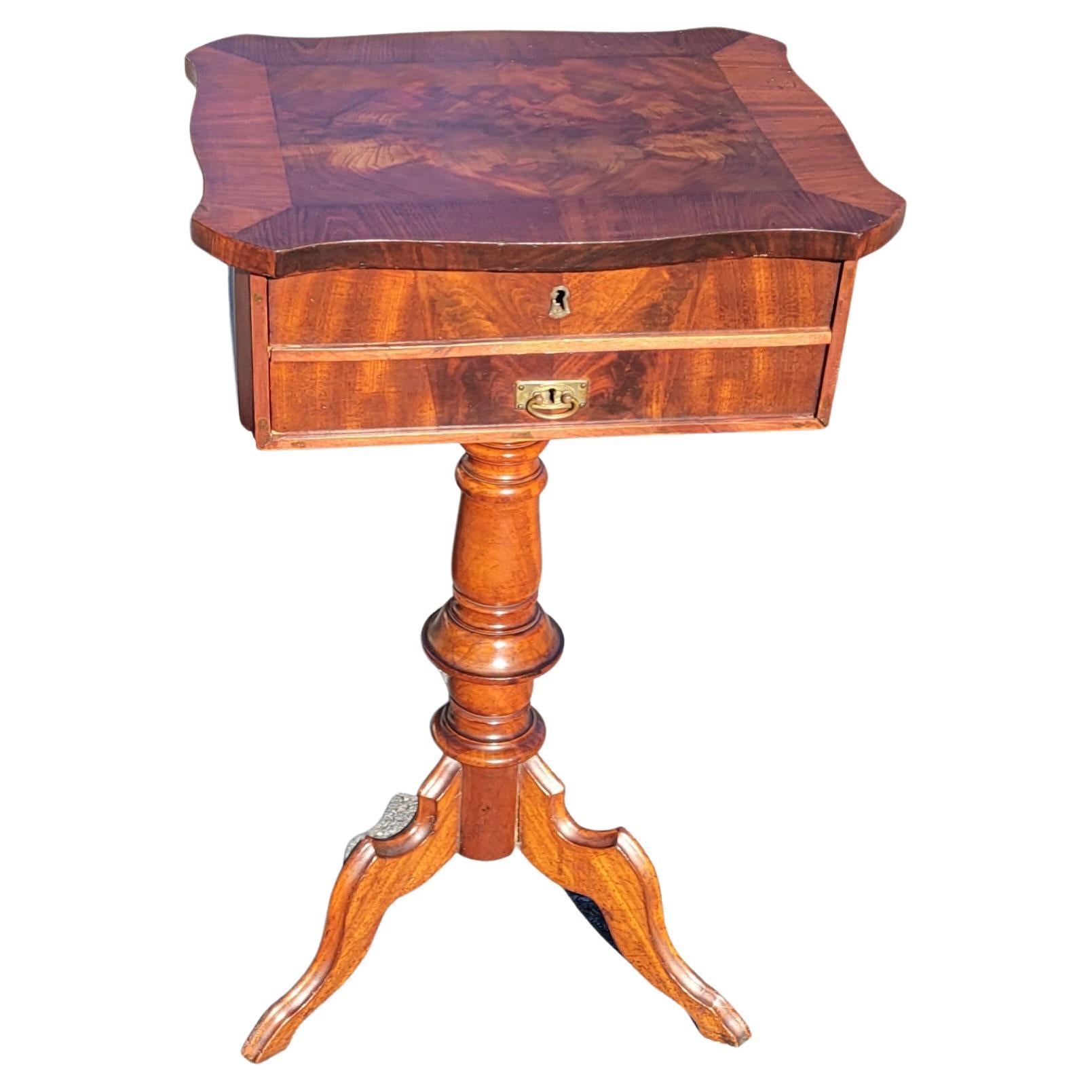 A Biedermeier era Flame Mahogany pedestal 2-drawer sewing table or side table. 
A Delicate Louis Philippe side table or sewing table out of Germany from the late 19th century around 1870. Standing on a beautifully base with three artfully processed