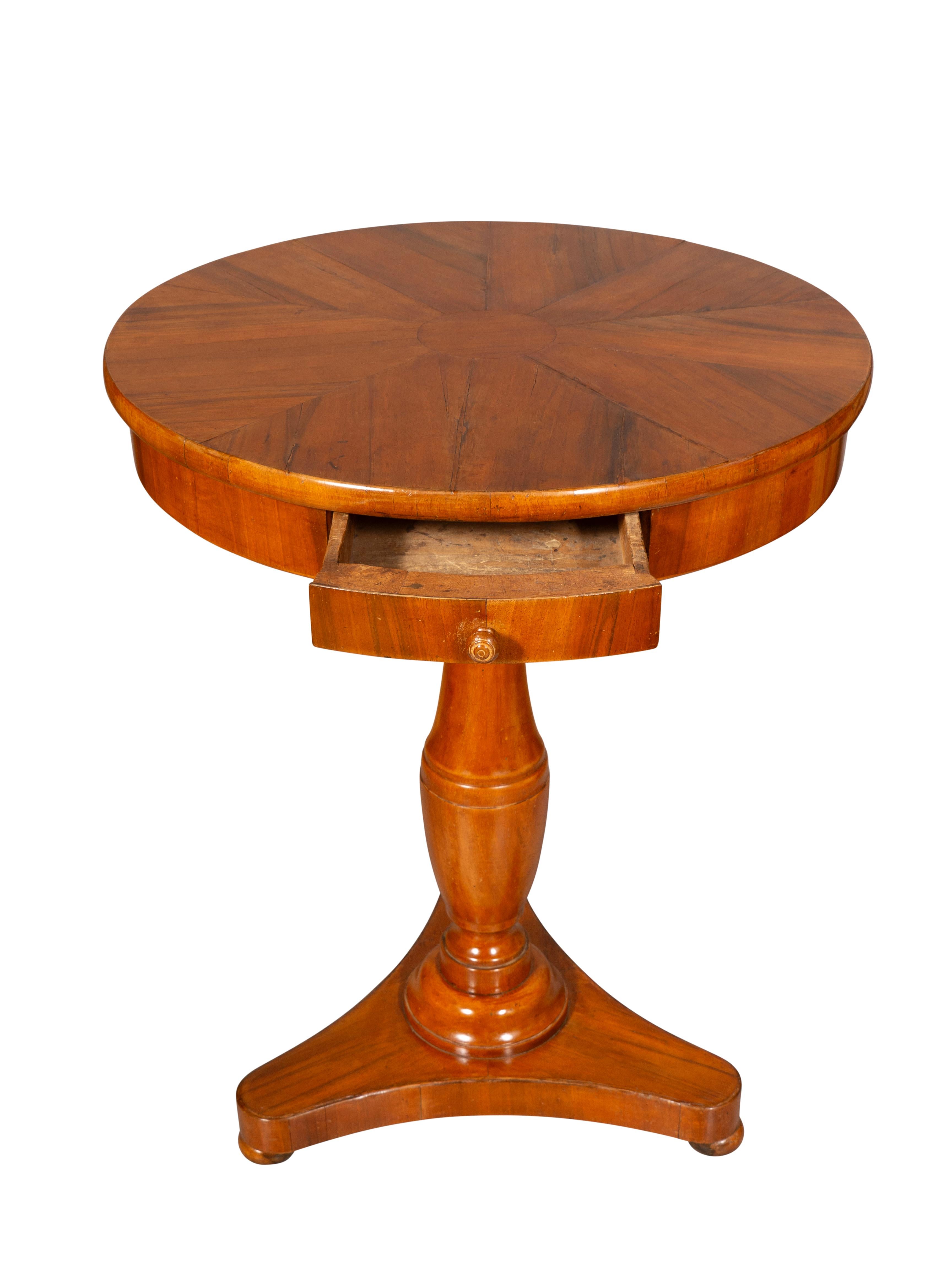 Plateau circulaire à décor figuré sur une frise avec un tiroir. Support circulaire tourné se terminant par une base tripartite avec des pieds en chignon aplatis.