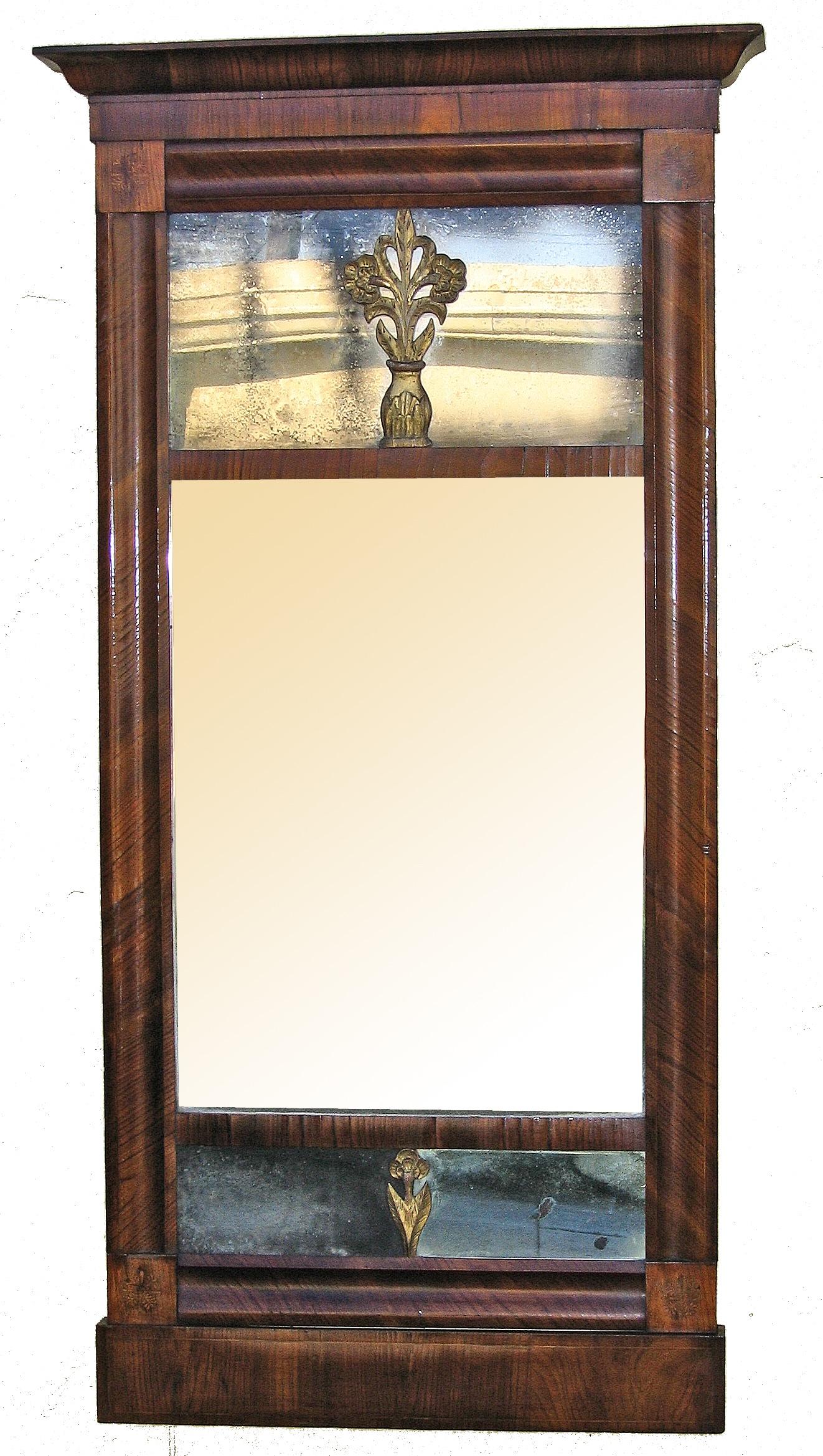 Biedermeier highly figured mahogany pier mirror, c1800. Original mirror plate and back. The mirror has carved gessoed and gilded wood mounts. The corners are inlaid with satinwood, floral inlay. 
Upper plate is 20.5
