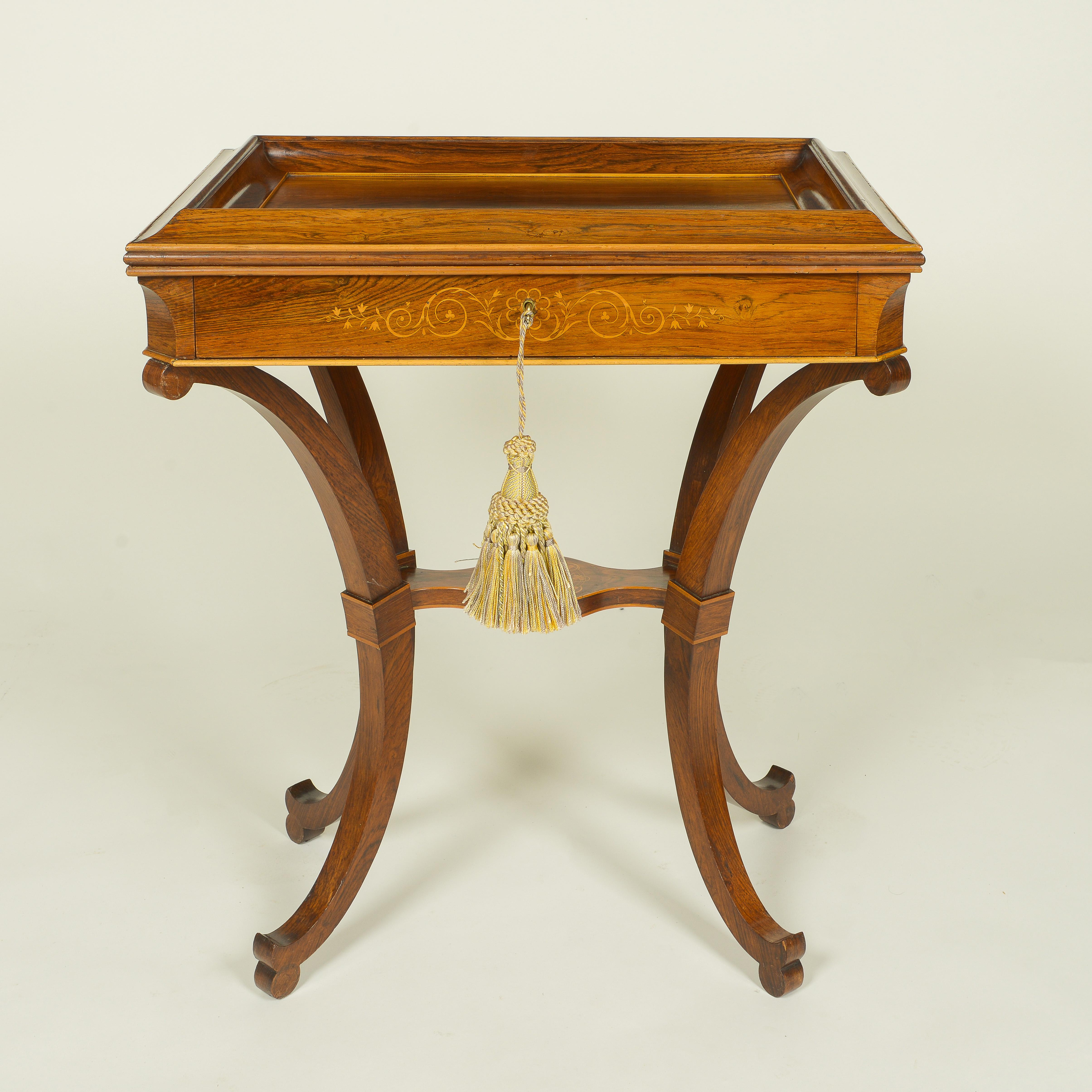 The rectangular top deeply dished with a cushion-molded edge, over a frieze drawer inlaid with arabesque scrollwork; raised on four incurved legs joined by a shaped inlaid platform stretcher; with fruitwood banding throughout. With key.