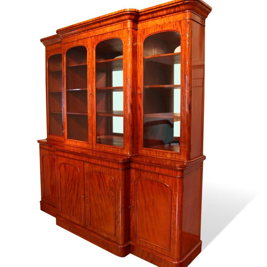 Large Biedermeier library bookcase with protruding middle section and glazed doors. The base cabinet has four doors and has a height of 97 cm. The bookcase is veneered with mahogany and shows a beautiful wooden grain.