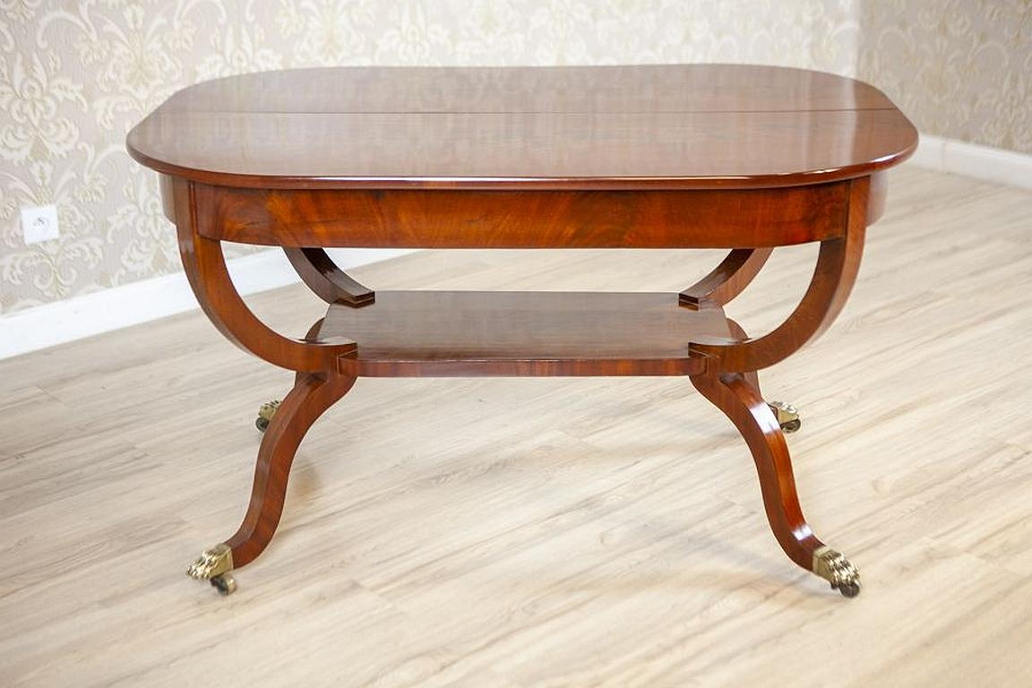 Biedermeier Mahogany center table from the late 19th century

The top with rounded corners is composed of two sections and supported on bents legs, which are finished with metal decorations in the form of lion paws. There is a shelf at the