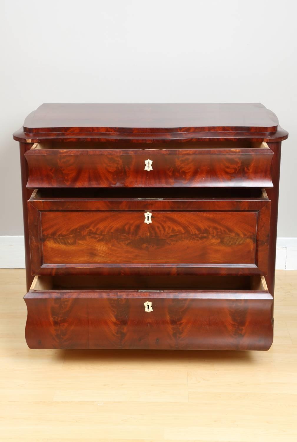 Biedermeier mahogany chest of drawers, circa 1840. Chest of drawers from Germany Biedermeier period. Featuring three drawers with original keys, which also serve as hardware. The chest has been professionally restored and polished by hand with