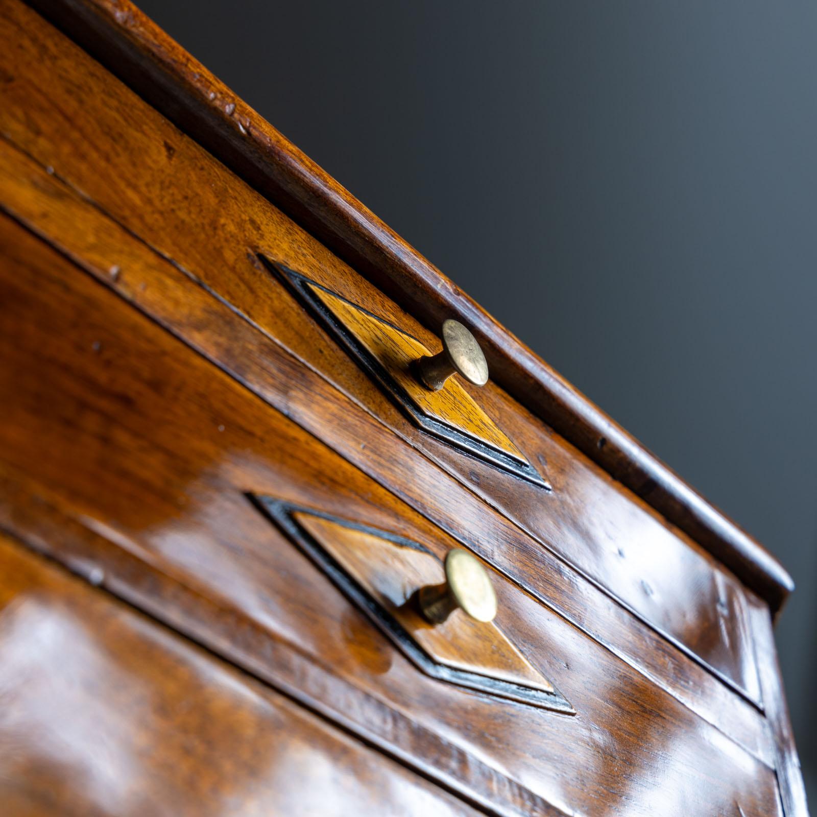 Questa piccola cassettiera Biedermeier in miniatura emana fascino ed eleganza. Realizzato in legno di noce, presenta quattro cassetti ornati da motivi a forma di diamante sui frontali, che aggiungono un tocco di raffinatezza al suo design. Le