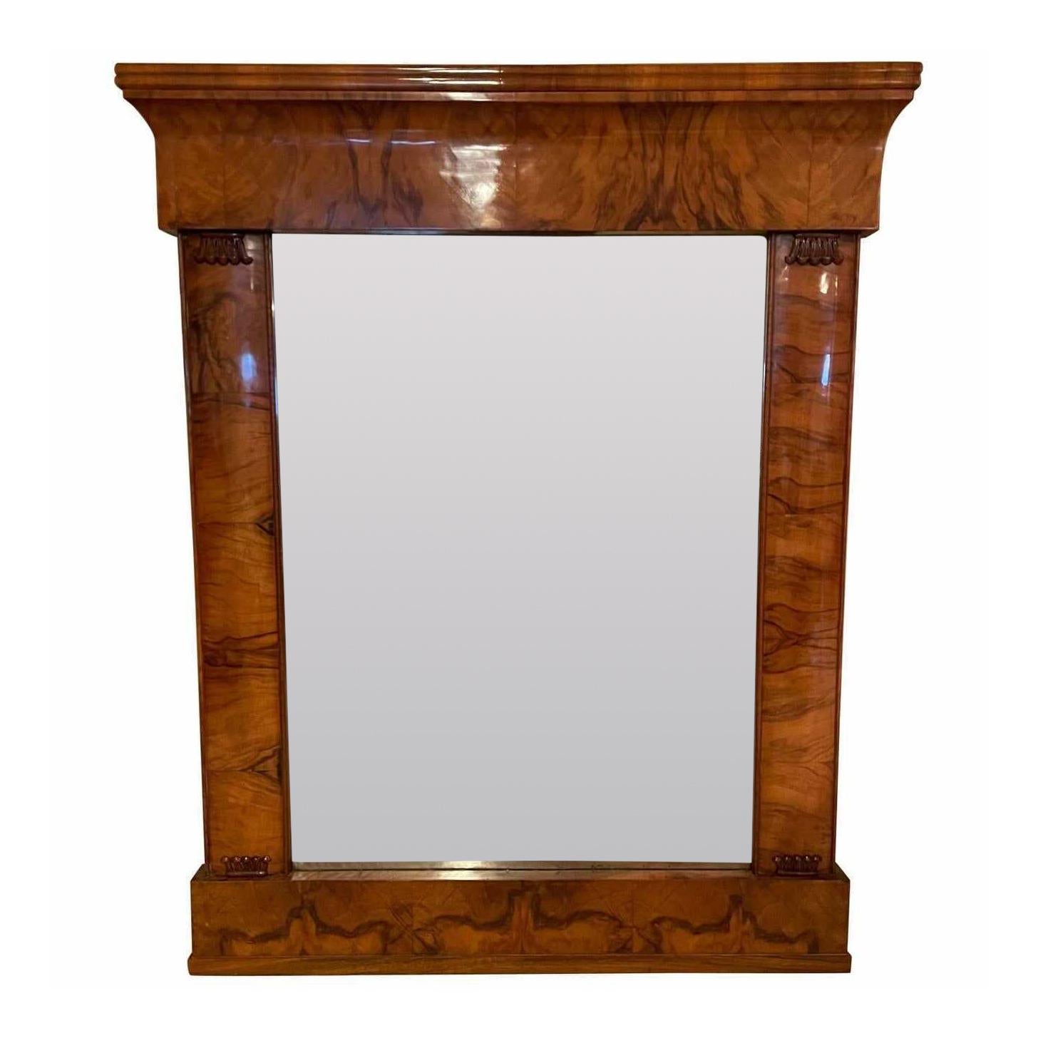 This beautiful original Biedermeier mirror dates back to circa 1820 and was made in South Germany. It is embellished with a beautiful walnut veneer and is additionally decorated with hand carved decorations.
The mirror glass is original.
The