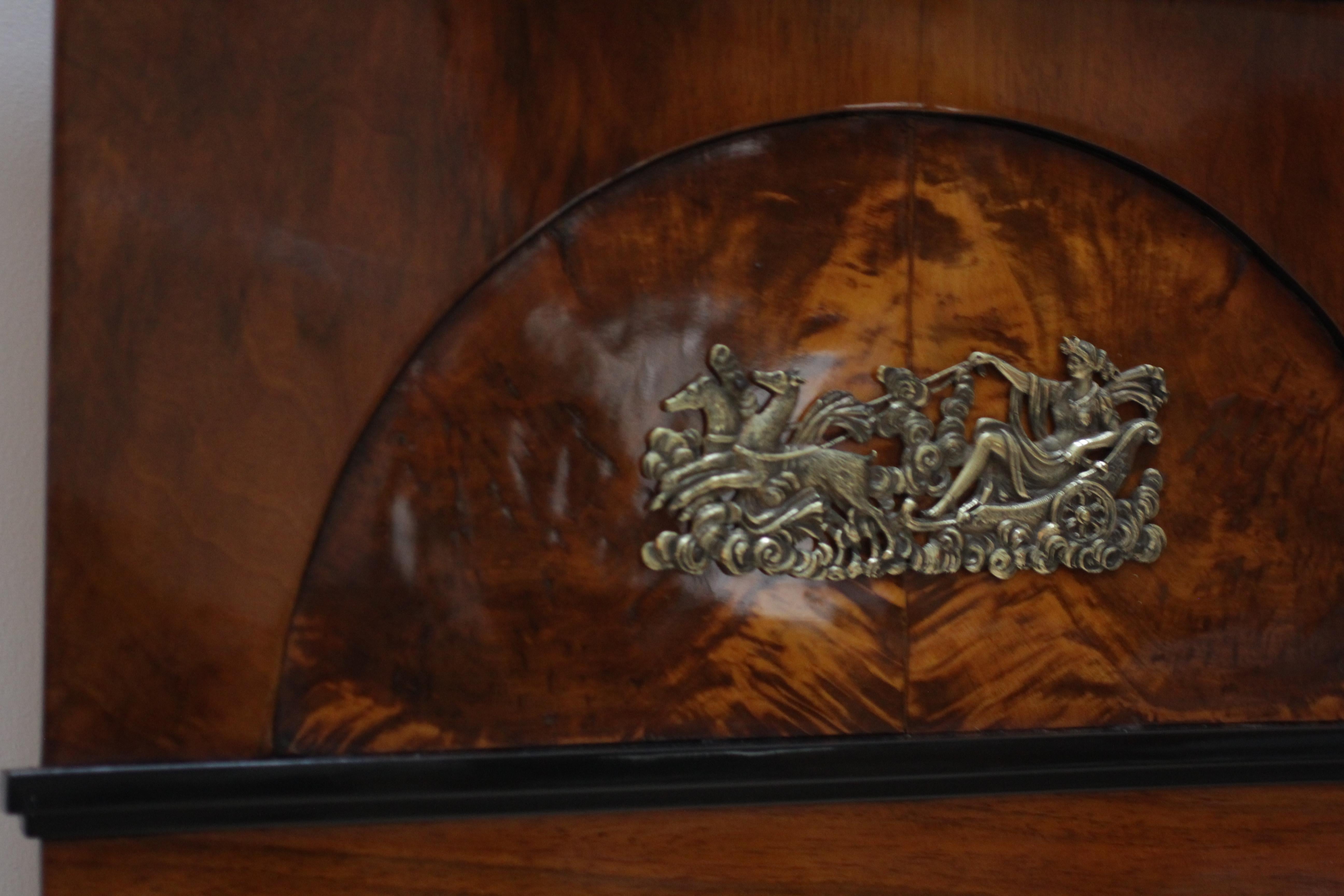 Elegant, early Biedermeier mirror with original brass application.

Walnut veneer and solid wood frame, partly ebonized. Half-mood wood inlay in flamed maple.
French polished.
Original old mirrorglass.