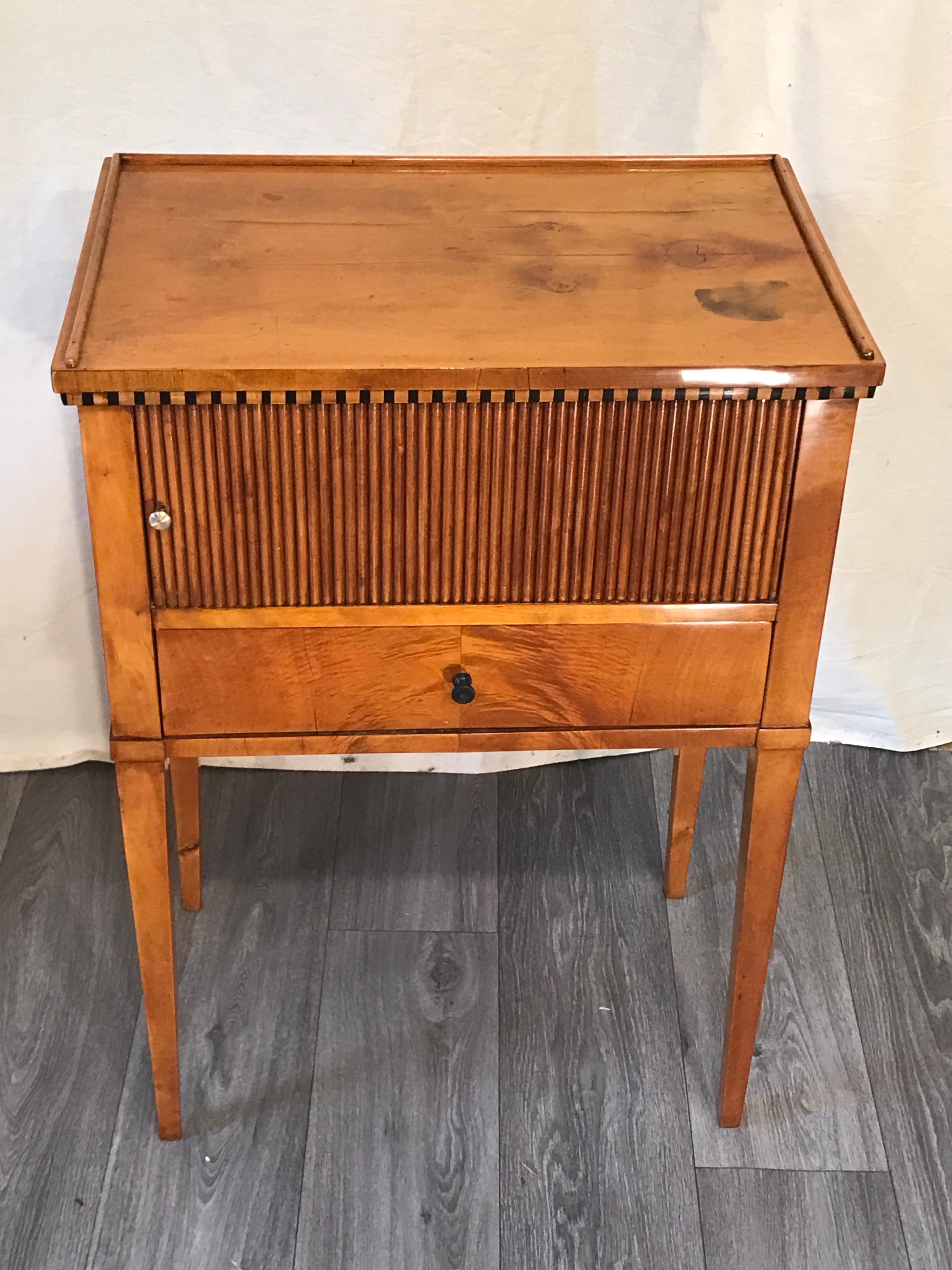 Biedermeier Nightstand or small cabinet, South Germany 1815-20, cherry veneer. Beautiful original piece. It has a pretty blinds door and one drawer. A wooden gallery is framing the top. Cherrywood veneer embellishes all sides of this small cabinet.