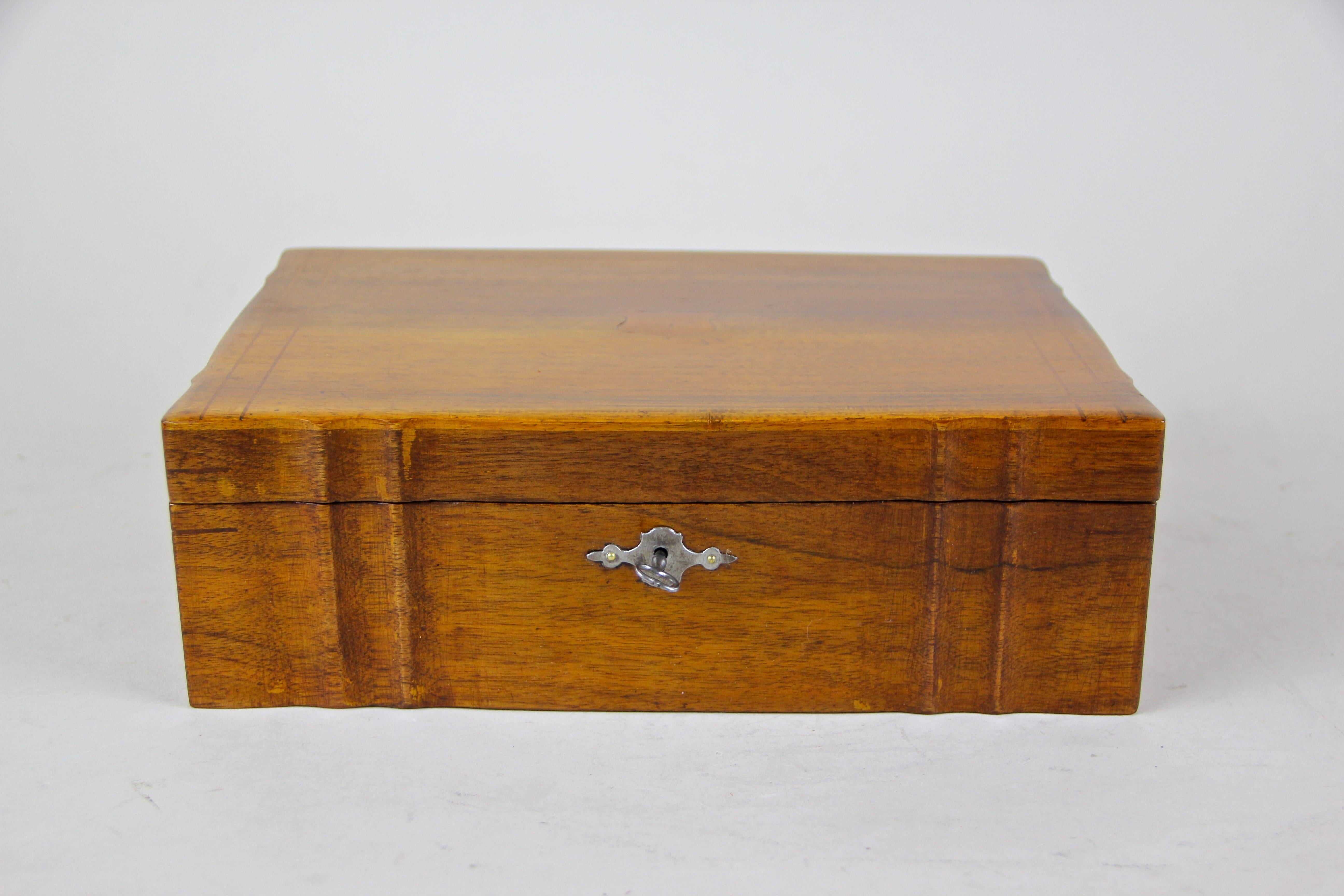 Lovely Biedermeier box veneered in fine nut wood. This nearly 170 year old wooden box shows nice maple threads inlays and a small coat arms on the lid. Coming with the original, fully functional lock, this box was preserved by a classic