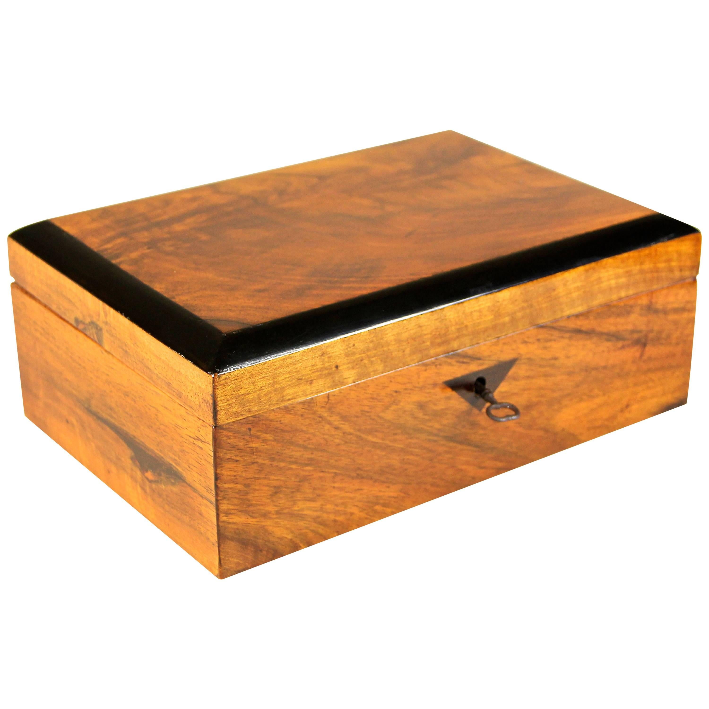 Lovely Biedermeier nut wood box from the early 19th century circa 1835 in Austria. A very decroative box veneered in fine nut wood. This simple but elegant shaped box shows a timeless design which is underlined by inlayed ebonized fruitwood framing