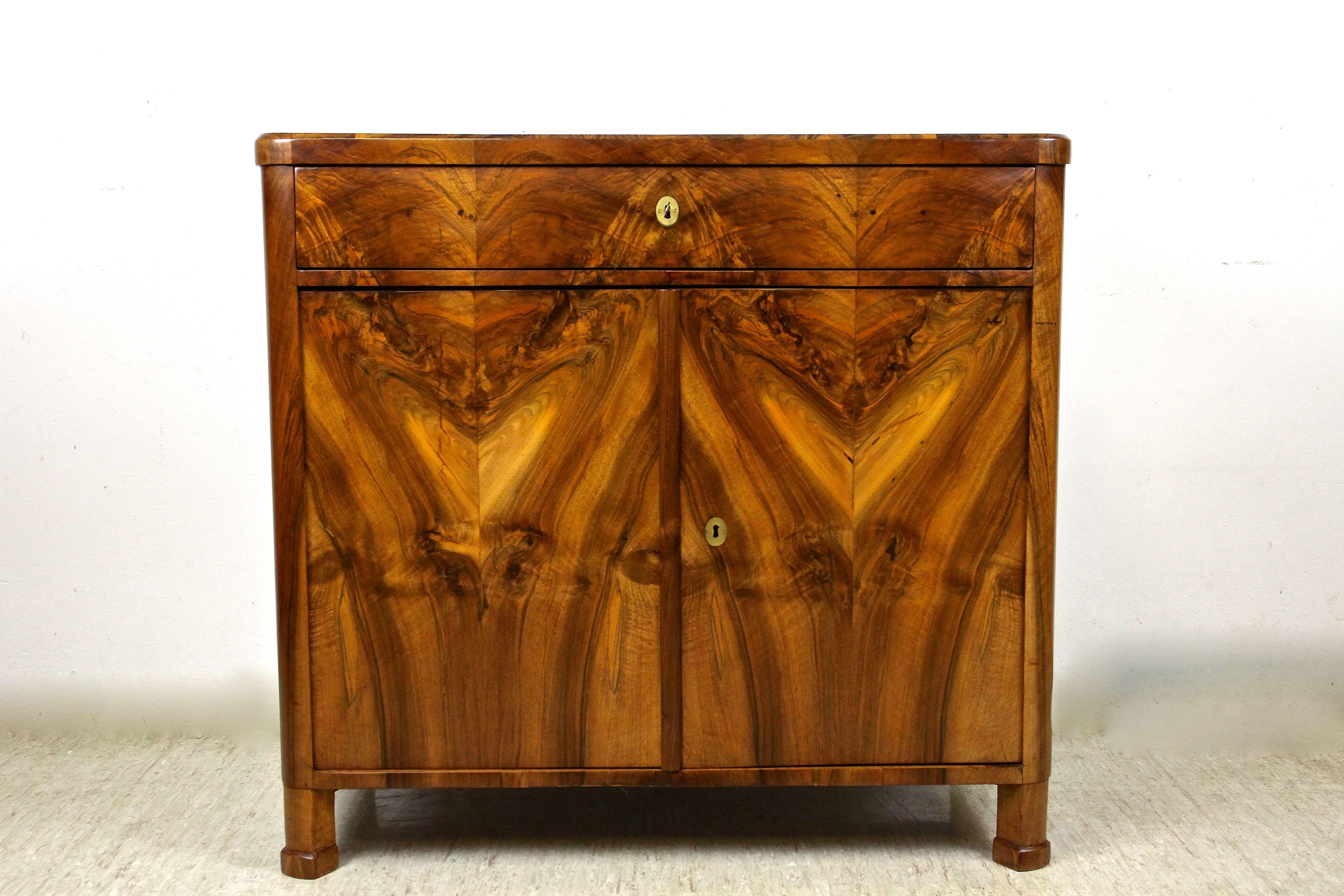 Outstanding 19th century Biedermeier nutwood trumeau commode from the early period around 1835 in Austria. Veneered with finest nutwood, this exceptional commode impresses with an absolute breathtaking mirrormatched grain that 