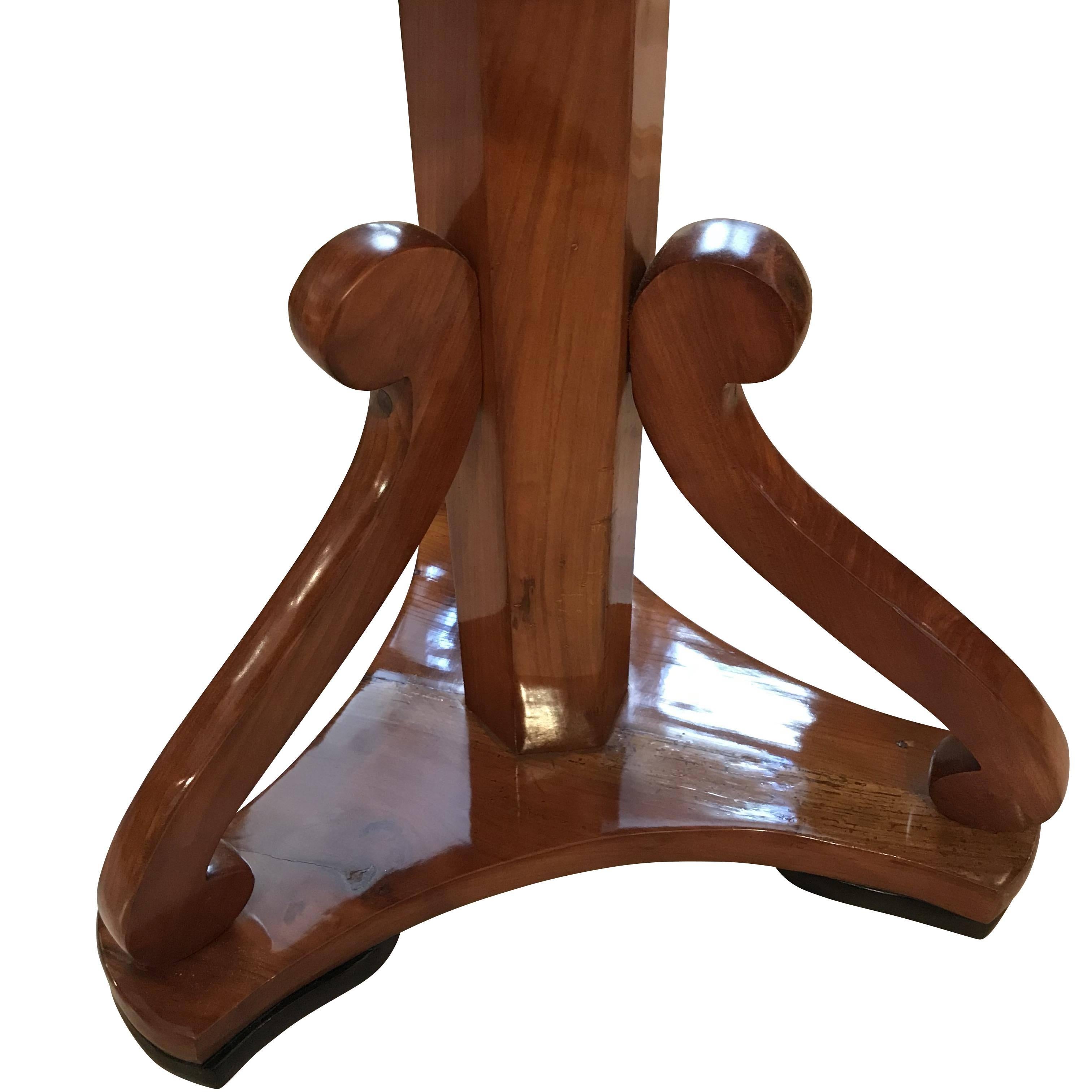 Very elegant, round Biedermeier side table entirely made of cherry solid wood. 

Beautiful pedestal leg with an octagonal center stand and three curved volutes. 

Restored condition with wonderful French polished.