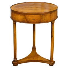 Tavolo del periodo Biedermeier del 1840 con piano rotondo, tre cassetti e gambe a colonna