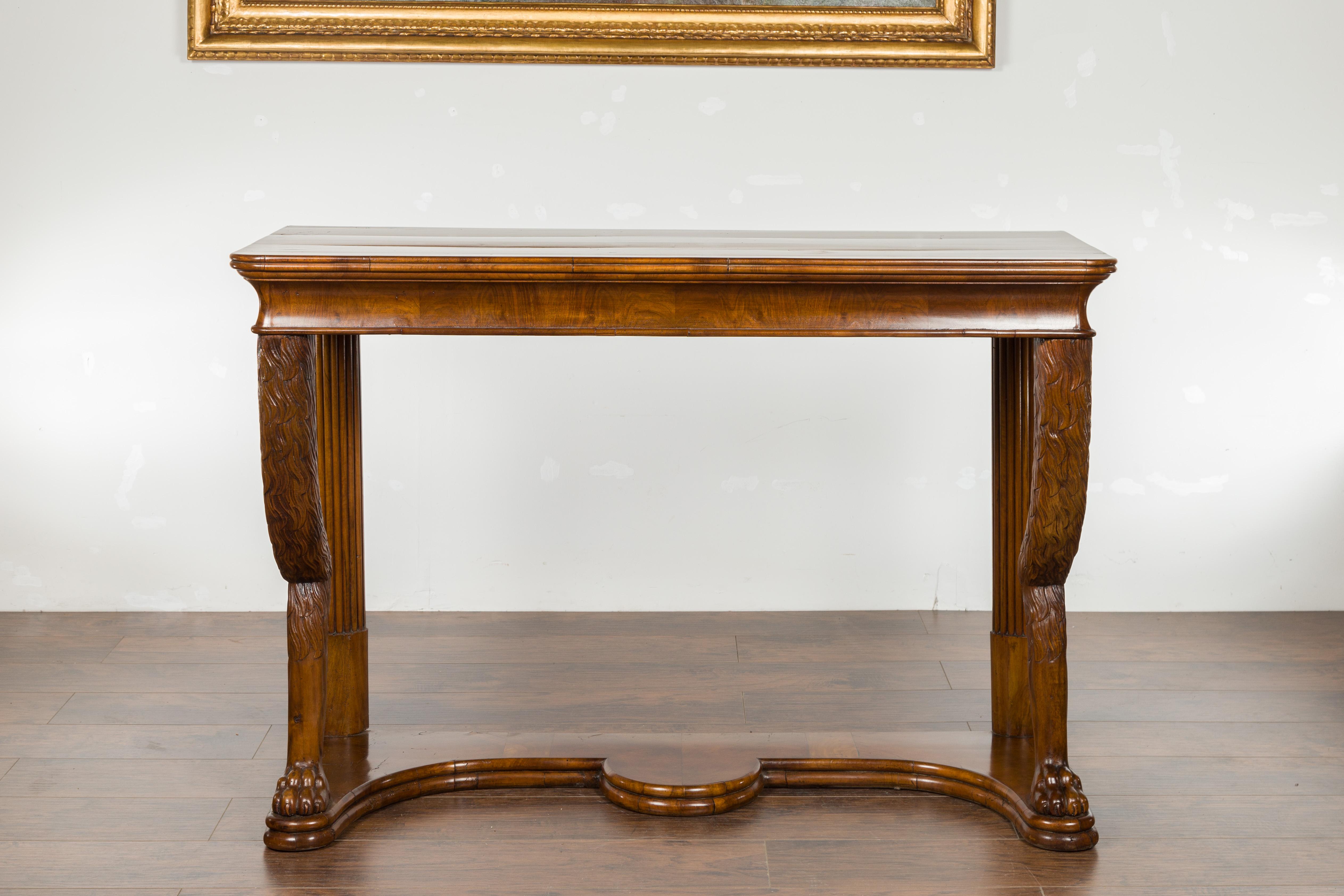 An Austrian Biedermeier period walnut console table from the mid-19th century, with fur style legs and lion paw feet. Created in Austria during the second quarter of the 19th century, this Biedermeier console table features a rectangular top with