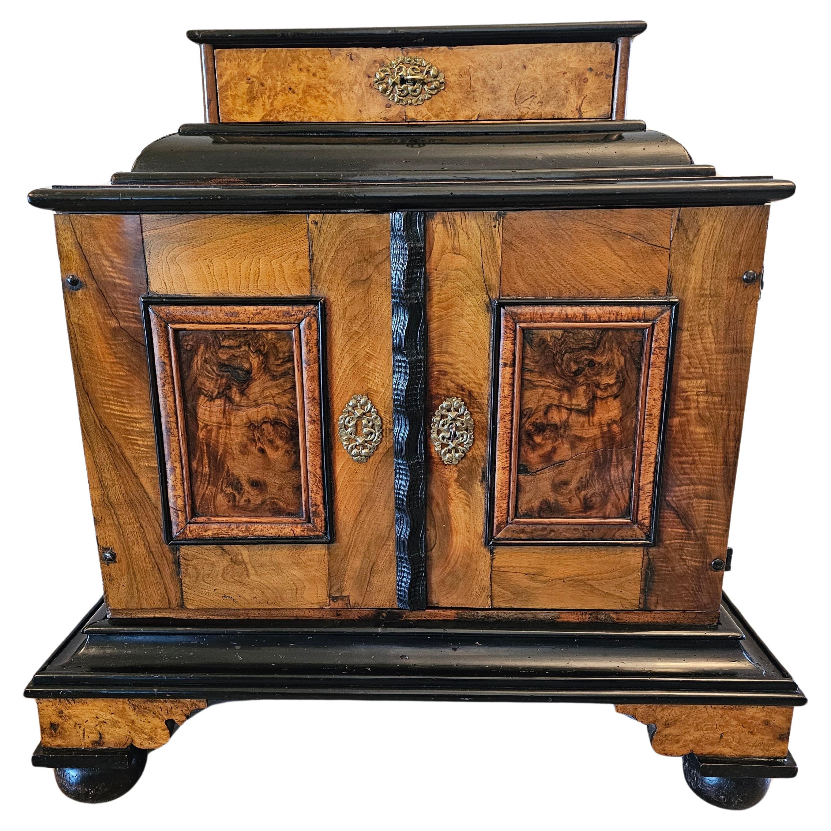Un beau cabinet de table - wunderkammer (cabinet de curiosités) de la période Biedermeier (1815-1848) en marqueterie de noyer et d'érable, avec quinze tiroirs et des compartiments secrets dissimulés, vers 1820. 

Ce cabinet de curiosités