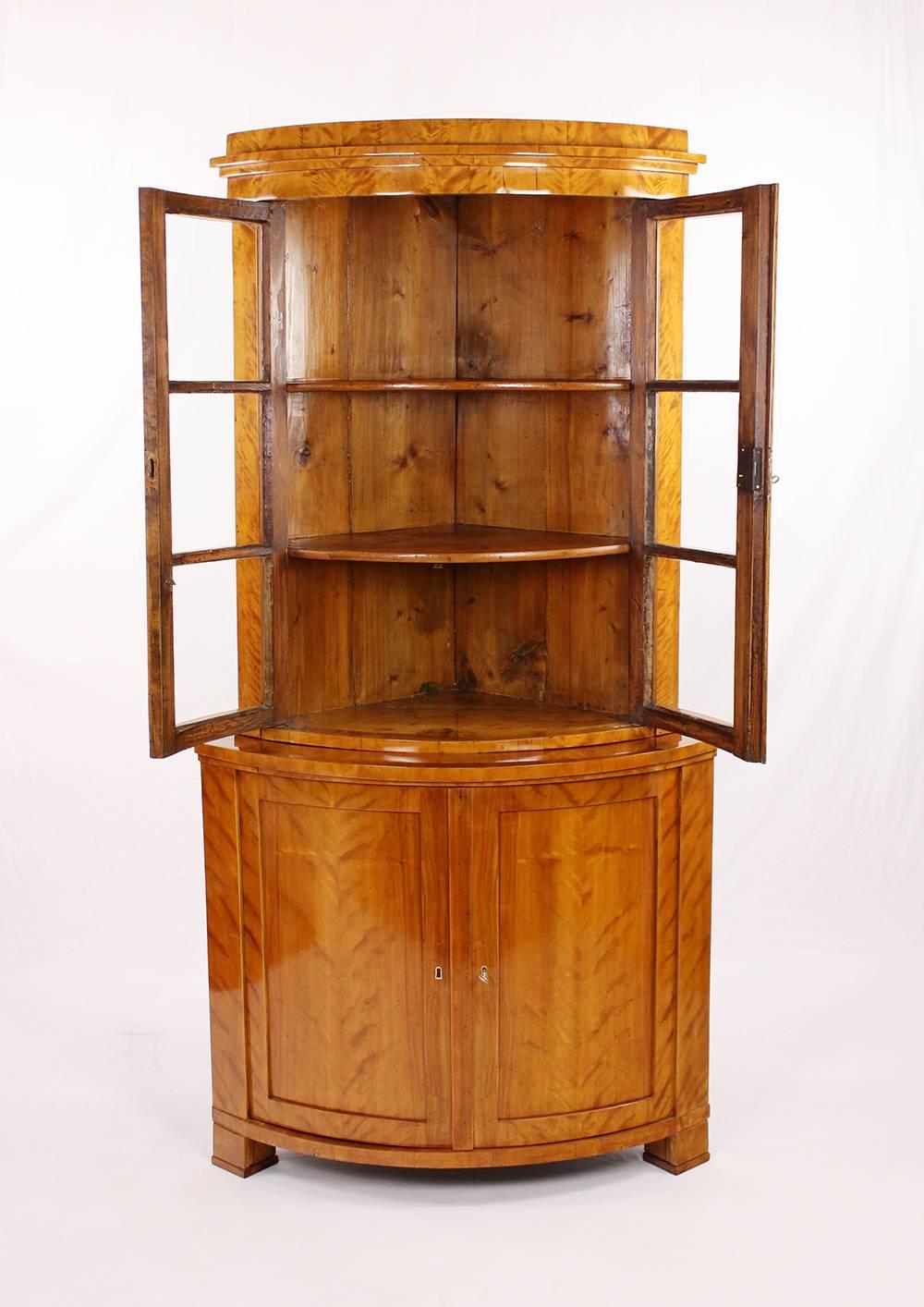 • Biedermeier period corner cupboard, glass cabinet, vitrine
• circa 1830-1840
• Birch veneered
• Two parts
• Front-glazed upper top
• Two-door drag with double doors
• Shelves inside
• Restored state
• French shellac hand polish.
•