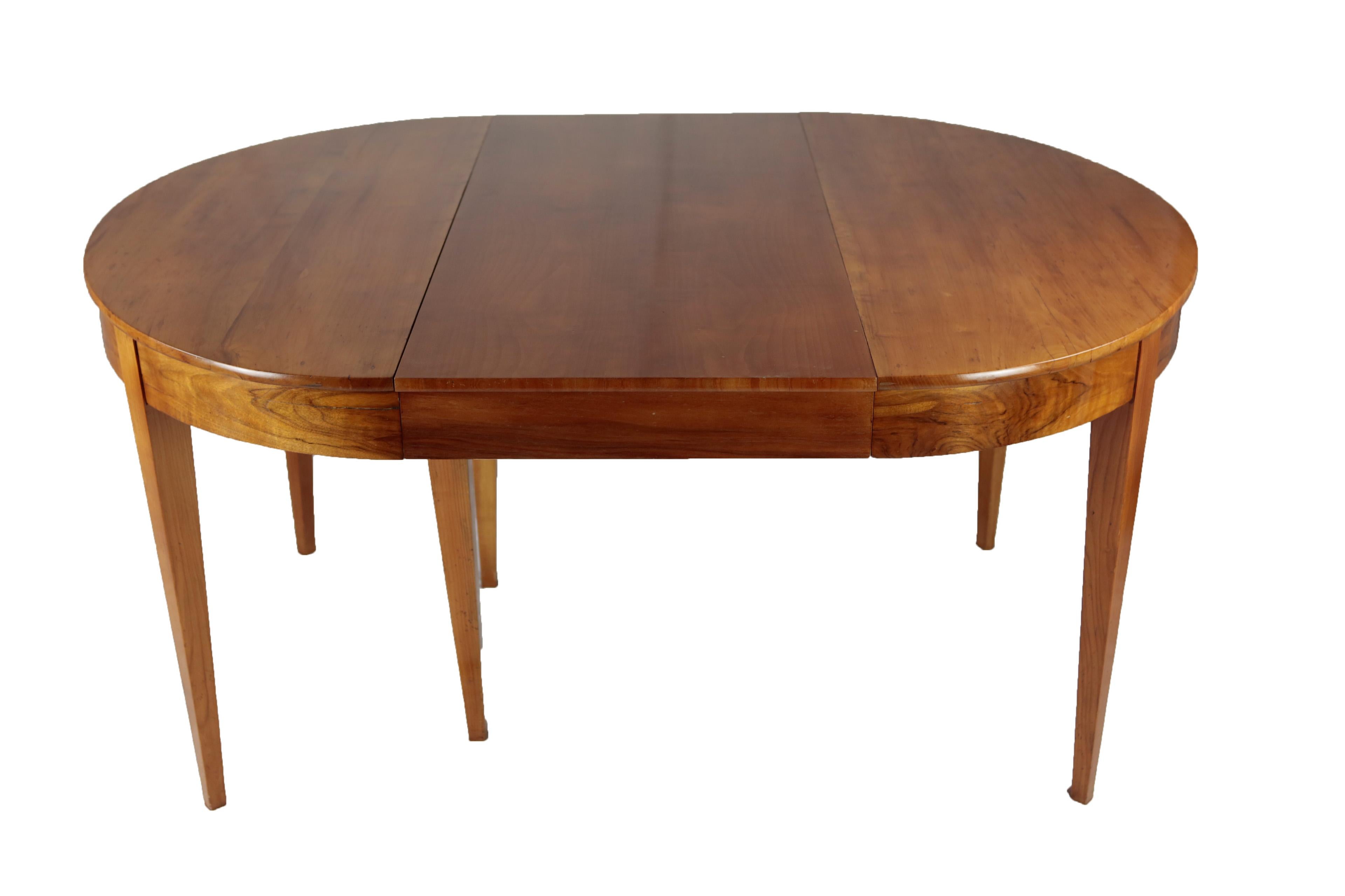 Beautiful and practical Biedermeier period dining table in cherrywood veneer and nutwood. The round table has a diameter of 104 cm and comes with 3 inlay plates (added later, because the original ones got lost), The inlay plates have a depth of 55.5