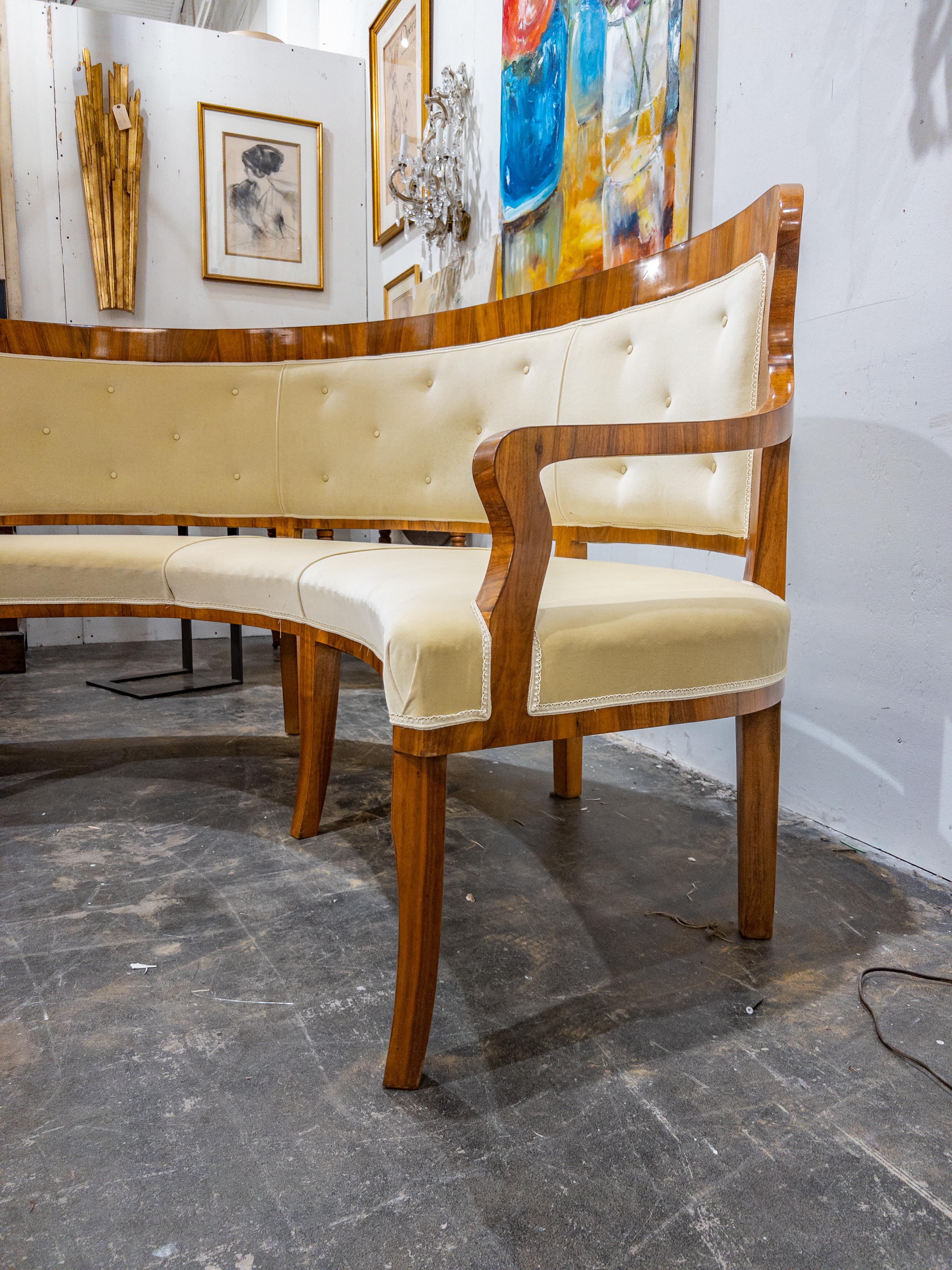The Biedermeier Period Rounded Upholstered Settee is a splendid representation of the classic Biedermeier style, which emerged during the early 19th century in Central Europe. This exquisite piece of furniture boasts a highly polished wood frame.