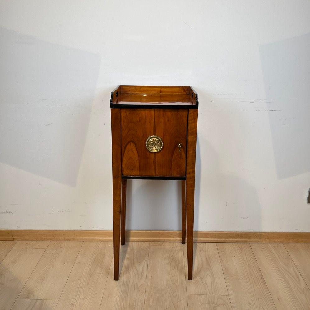 Elegant small Biedermeier Pillar cabinet or bedside table from southern Germany around 1820.
Cherry veneered and cherry solid wood. One door with central pressed brass fittings.
Top with shelf and carrying handles.
The small furniture is veneered on