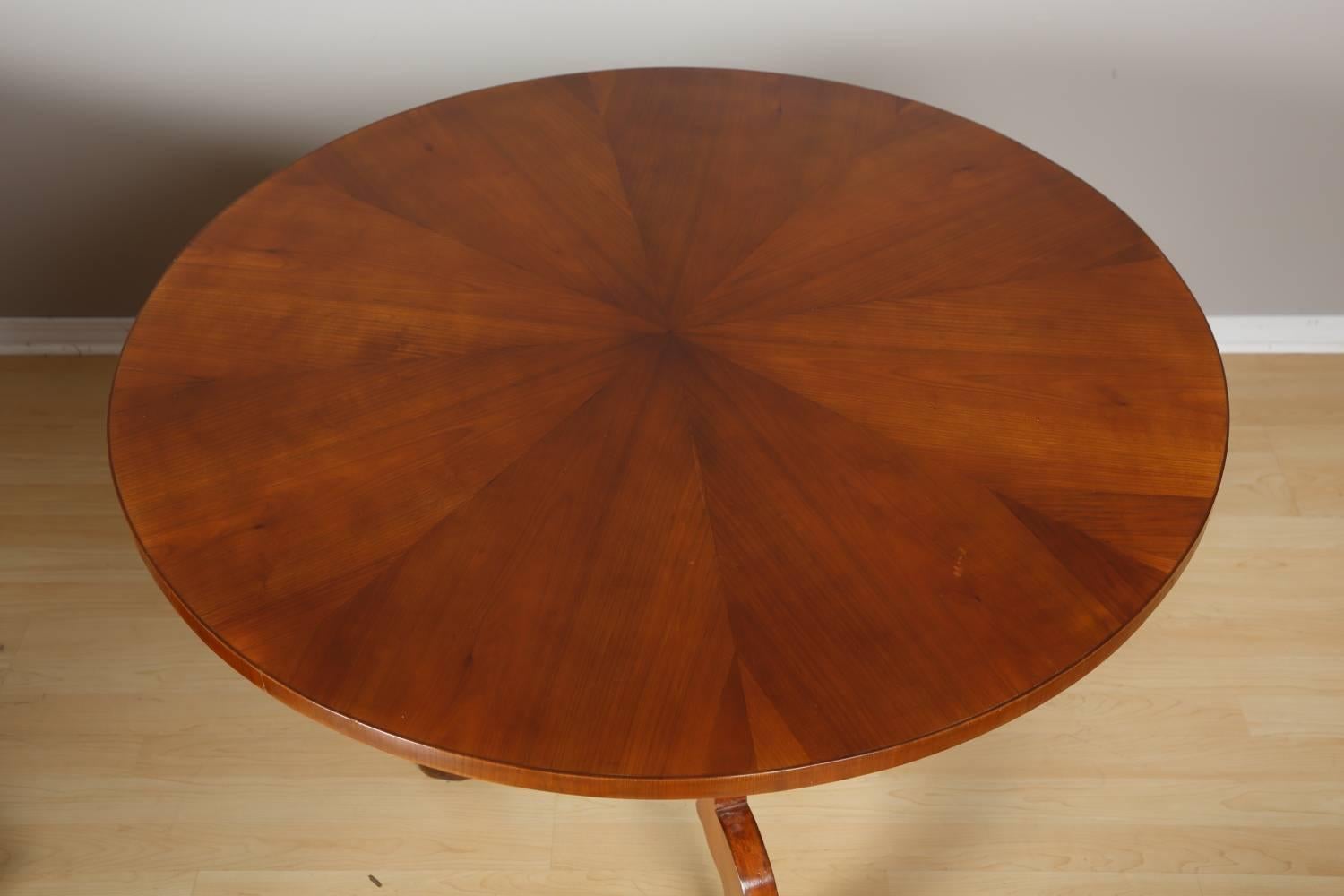 Biedermeier round table, circa 1850. Elegant round Biedermeier table in cherry wood. The table has been restored with respect for original color and patina, and hand polished with natural shellac.
