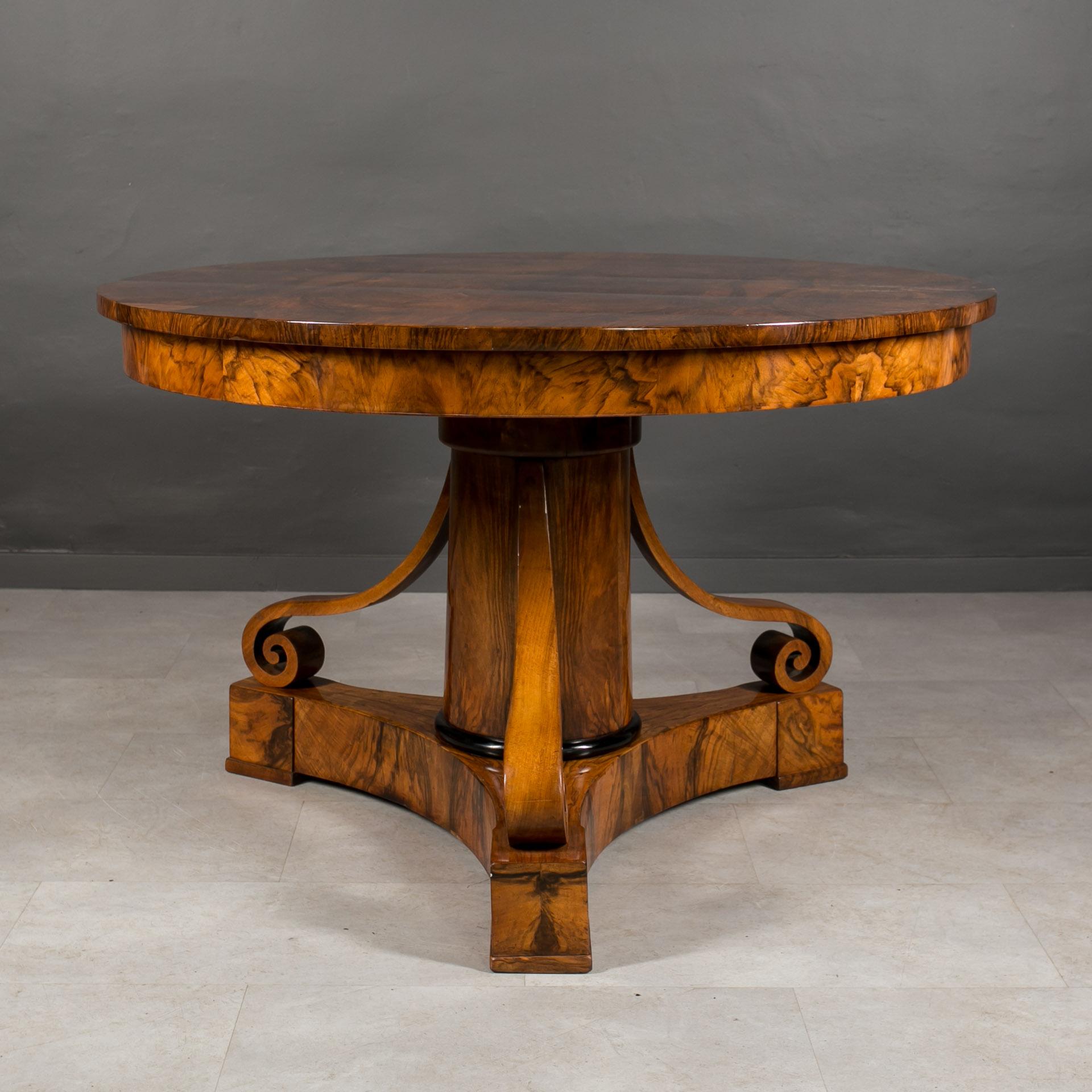 This charming Biedermeier round table, crafted in Germany circa 1830-1840, embodies timeless elegance and exceptional craftsmanship. Its stunning design features a meticulously sculpted leg adorned with ebonized accent at the base. The piece is