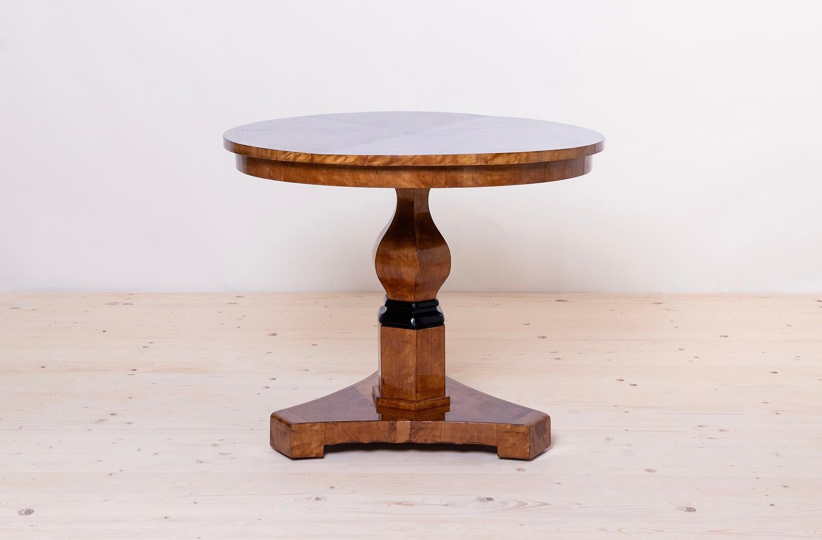 This Biedermeier round table was made in Germany around 1830. It is supported on a beautifully sculpted leg with ebonized detail. The piece is veneered with beautiful flame birch. It is after professional renovation process. Surface was finished