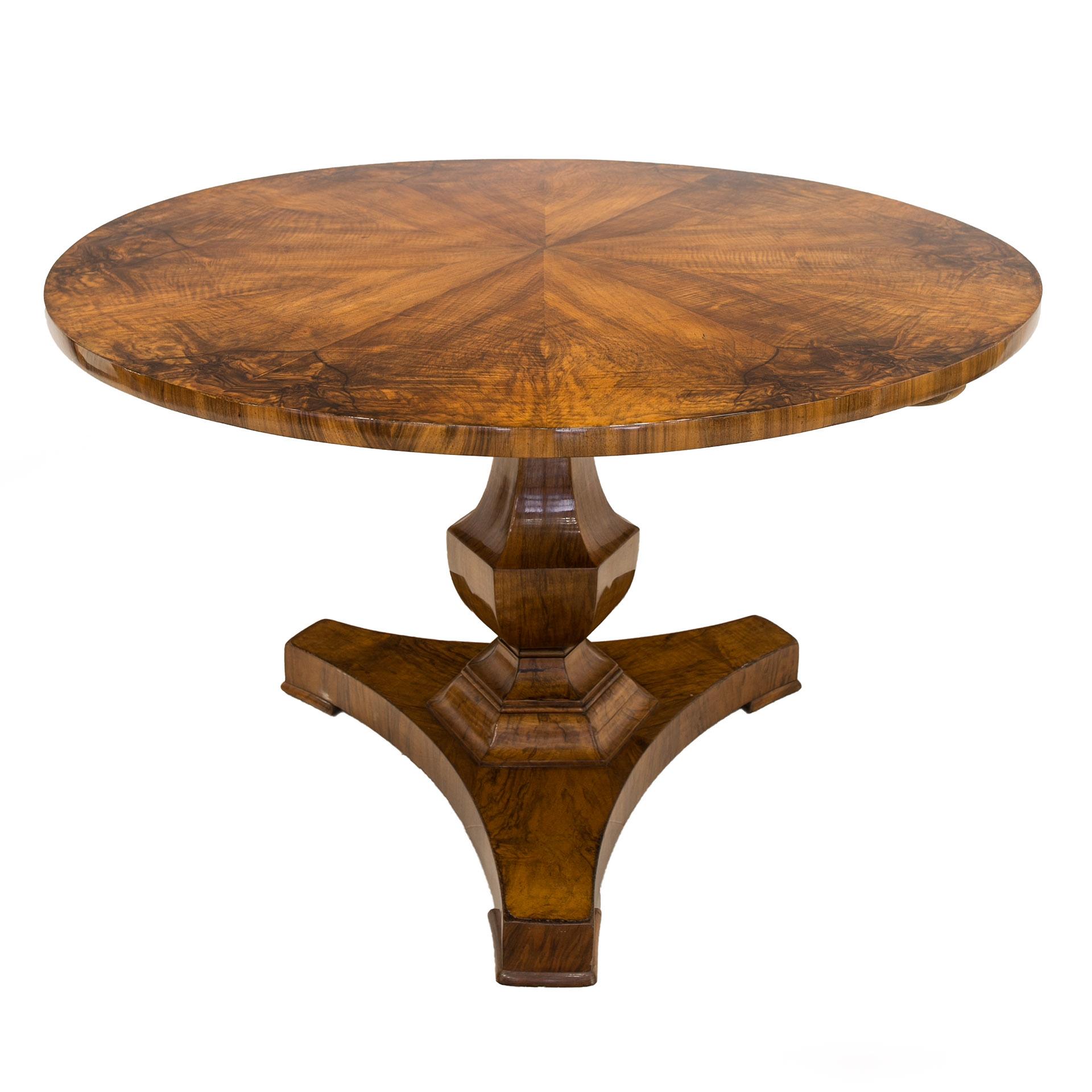 This Biedermeier round table comes from Germany and was made around early 19th century. It is supported on one solid, beautifully shaped leg made of walnut wood. The tabletop is veneered with 12 parts of walnut wood with extraordinary wood patterns.