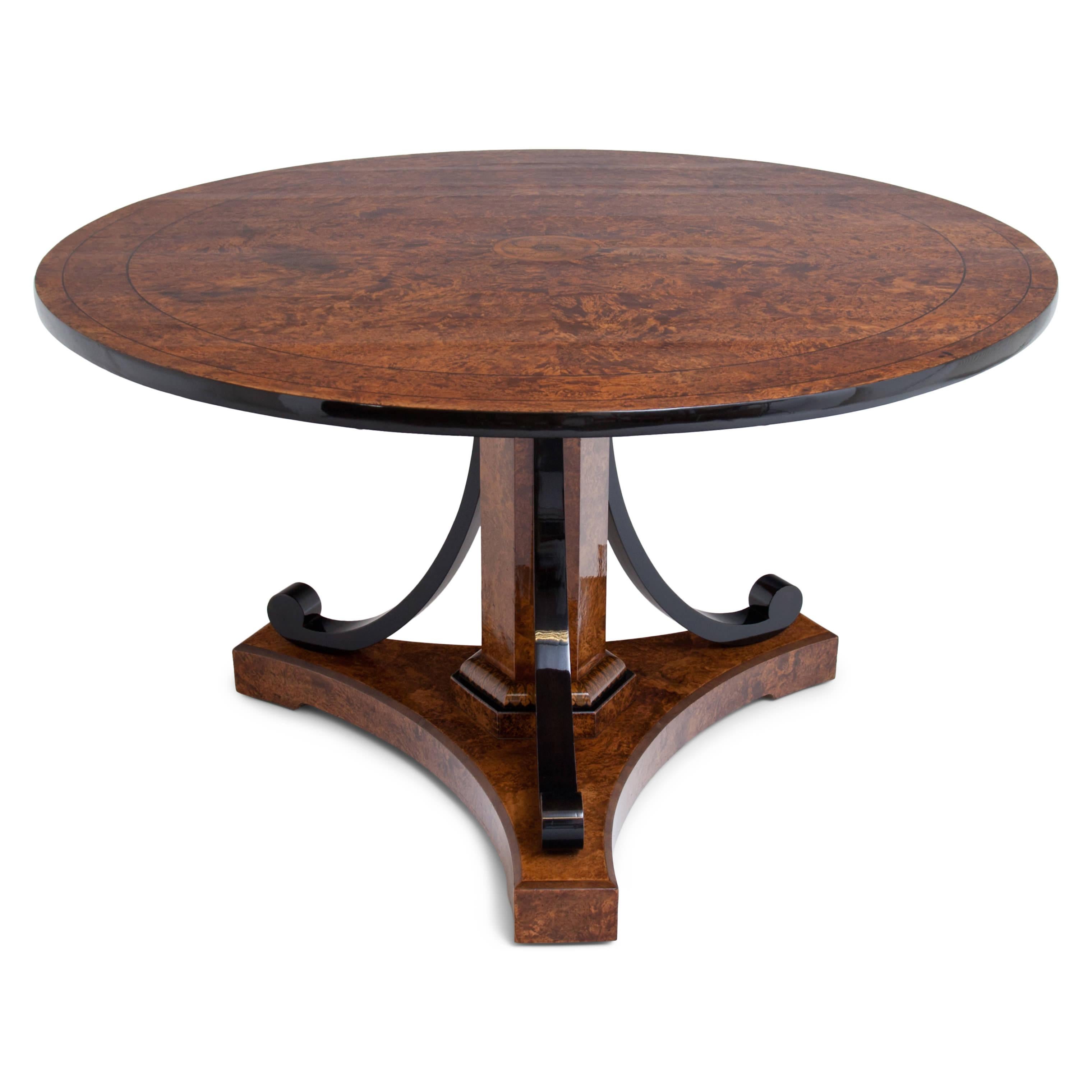 Salon table veneered in walnut root, on a trefoil stand with ebonised, rocaille-shaped legs around a hexagonal central foot with fire-shaded acanthus leaf decoration. The table top with ebonised edge and radial thread inlays shows a central flower